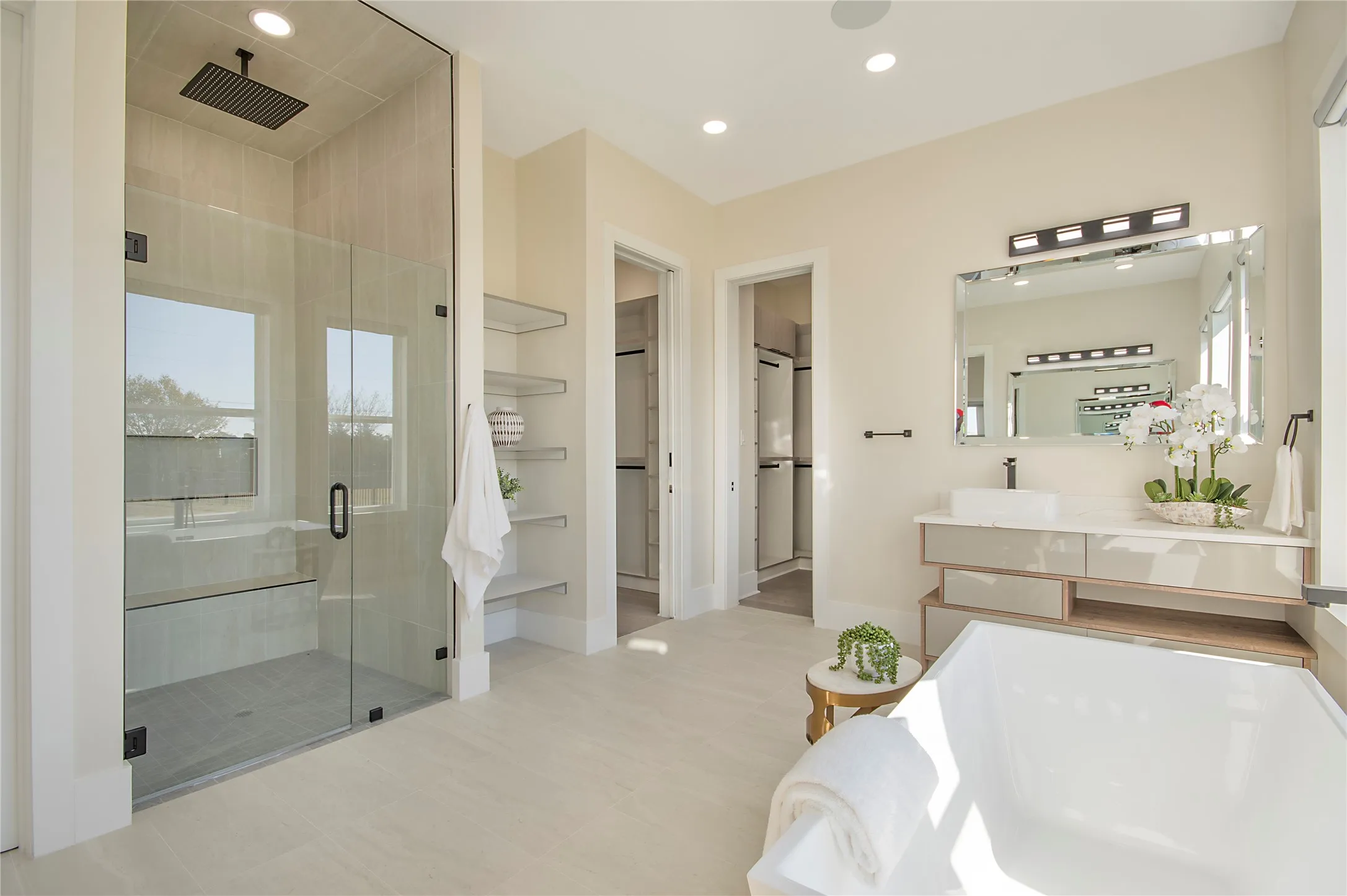 Bathroom featuring vanity, a spacious closet, a shower stall, a bathtub, and recessed lighting