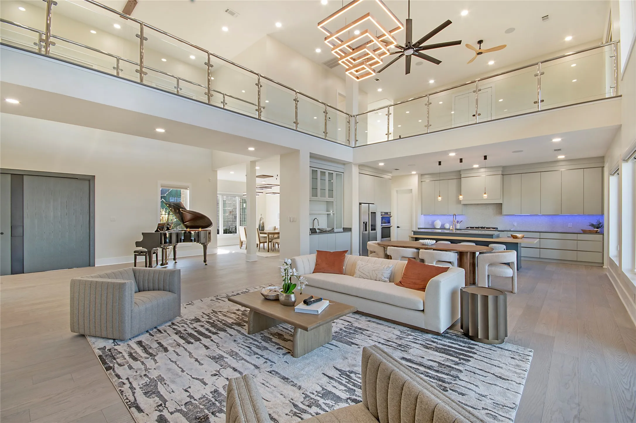 Living area with ceiling fan, light wood-style floors, recessed lighting, and a high ceiling