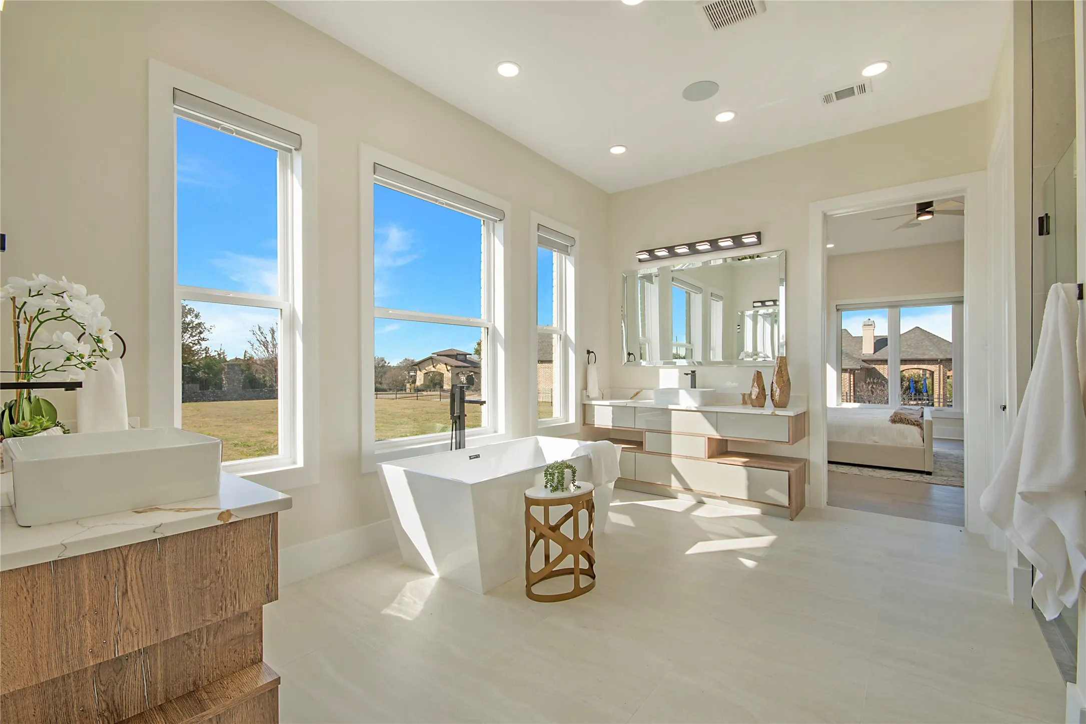 Ensuite bathroom with a freestanding bath, vanity, recessed lighting, and ceiling fan