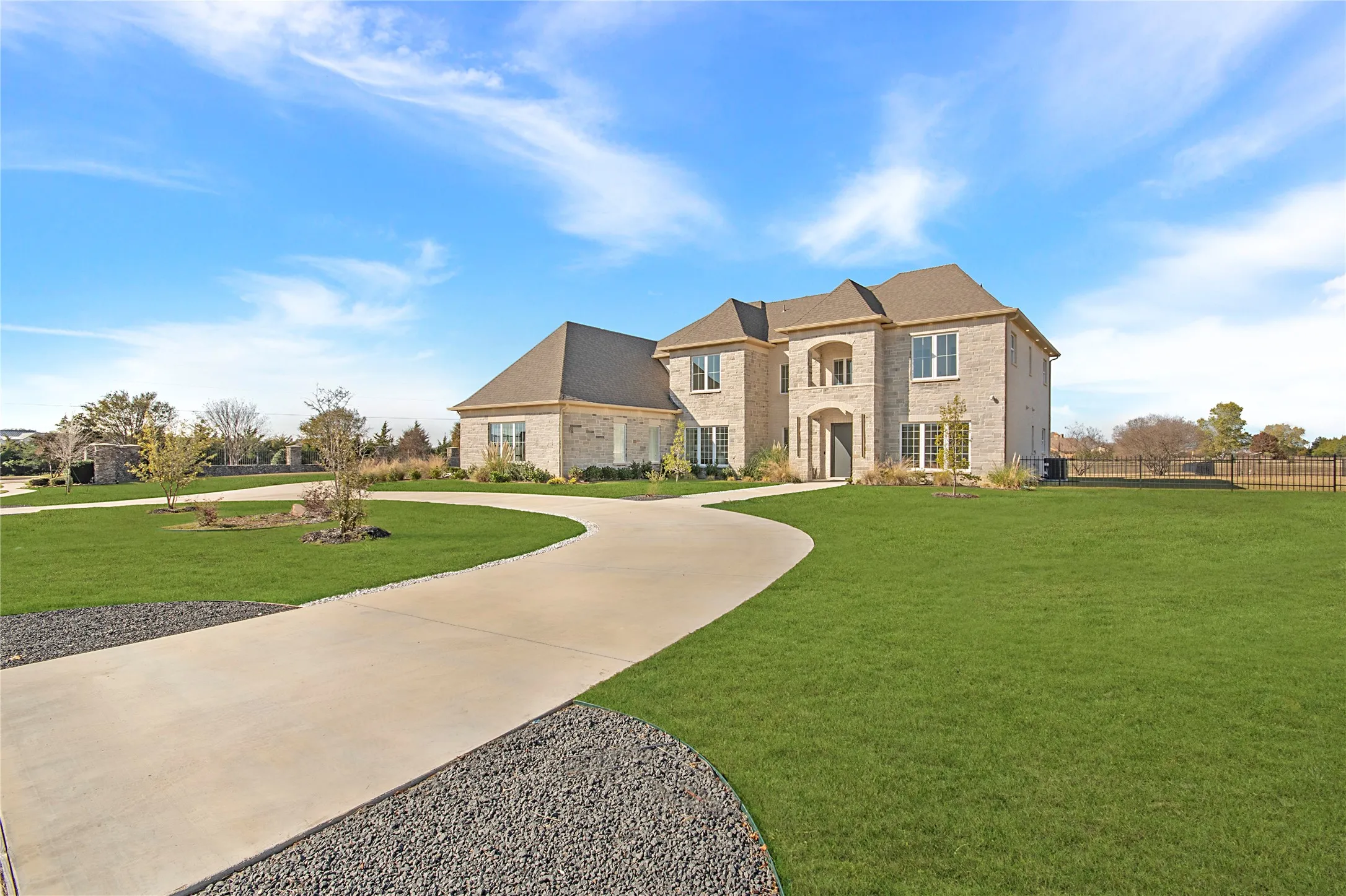 French provincial home with curved driveway and brick siding