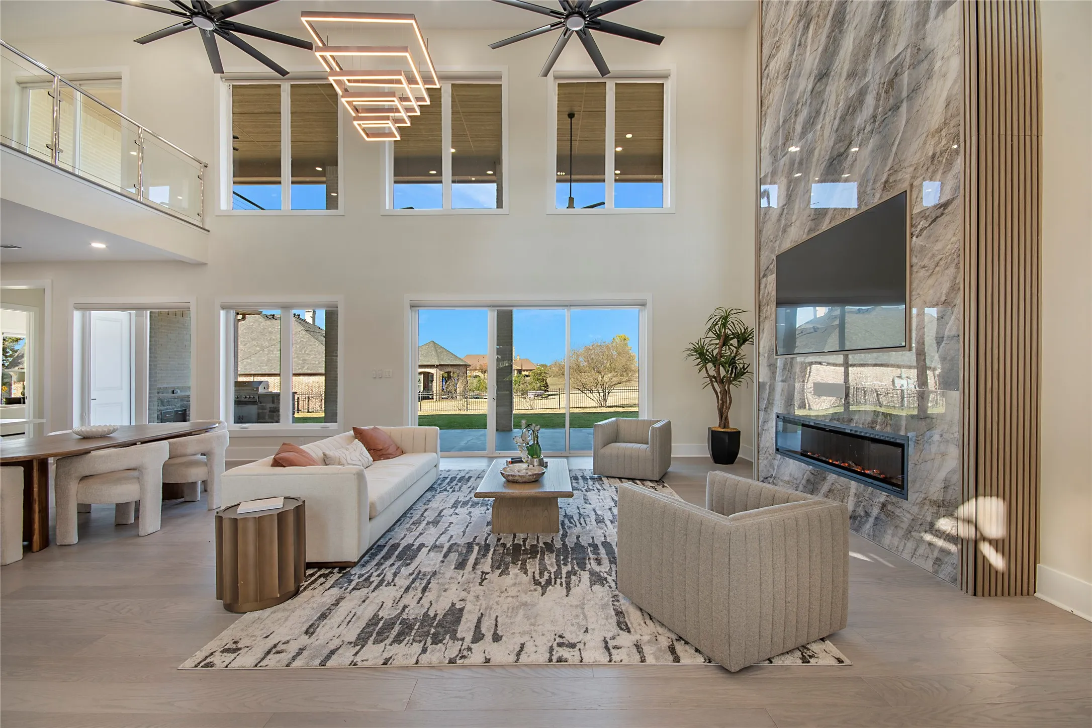 Living room featuring wood finished floors, a premium fireplace, ceiling fan, and a high ceiling