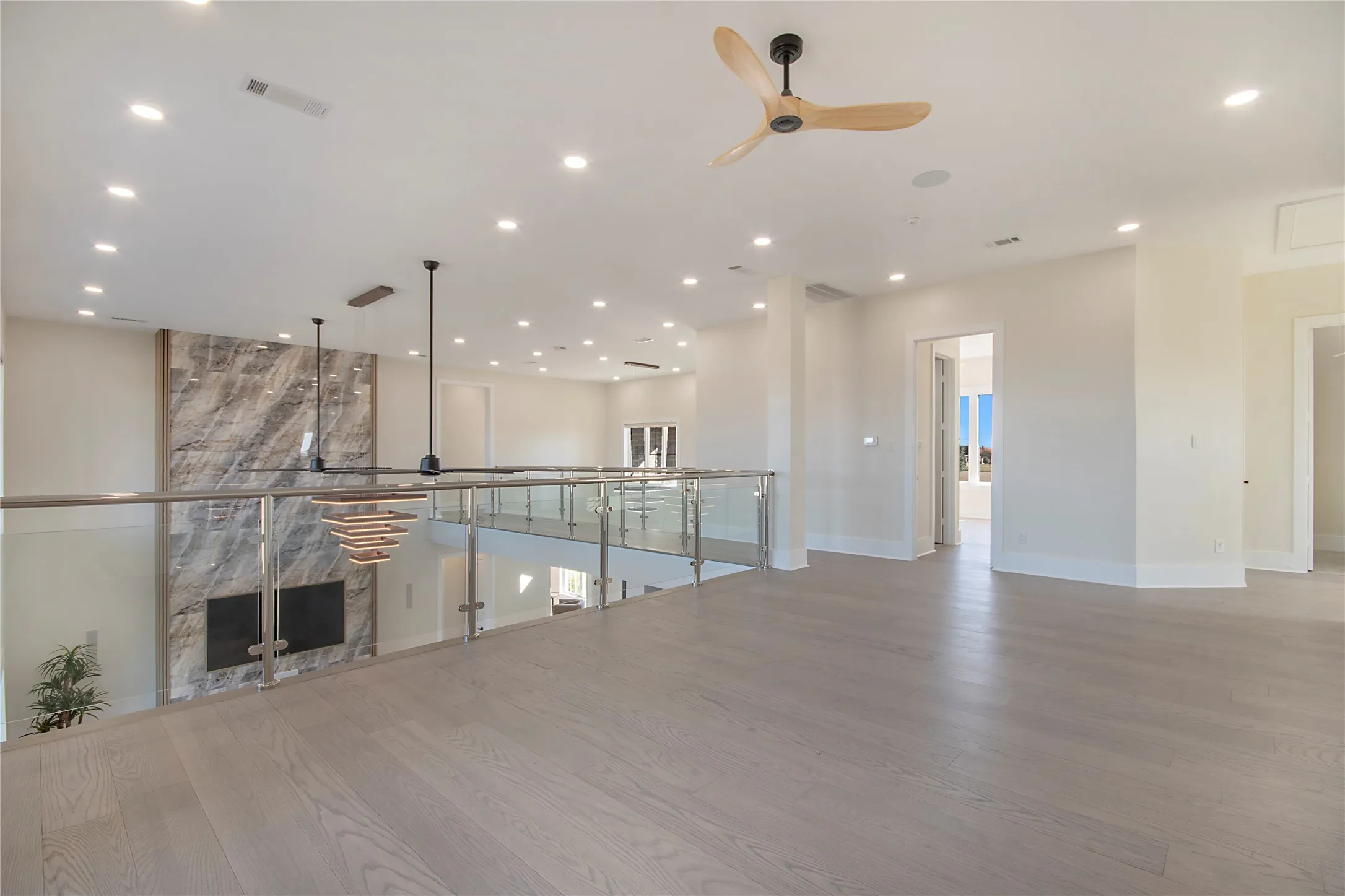 Unfurnished living room with a ceiling fan, recessed lighting, light wood finished floors, and a fireplace