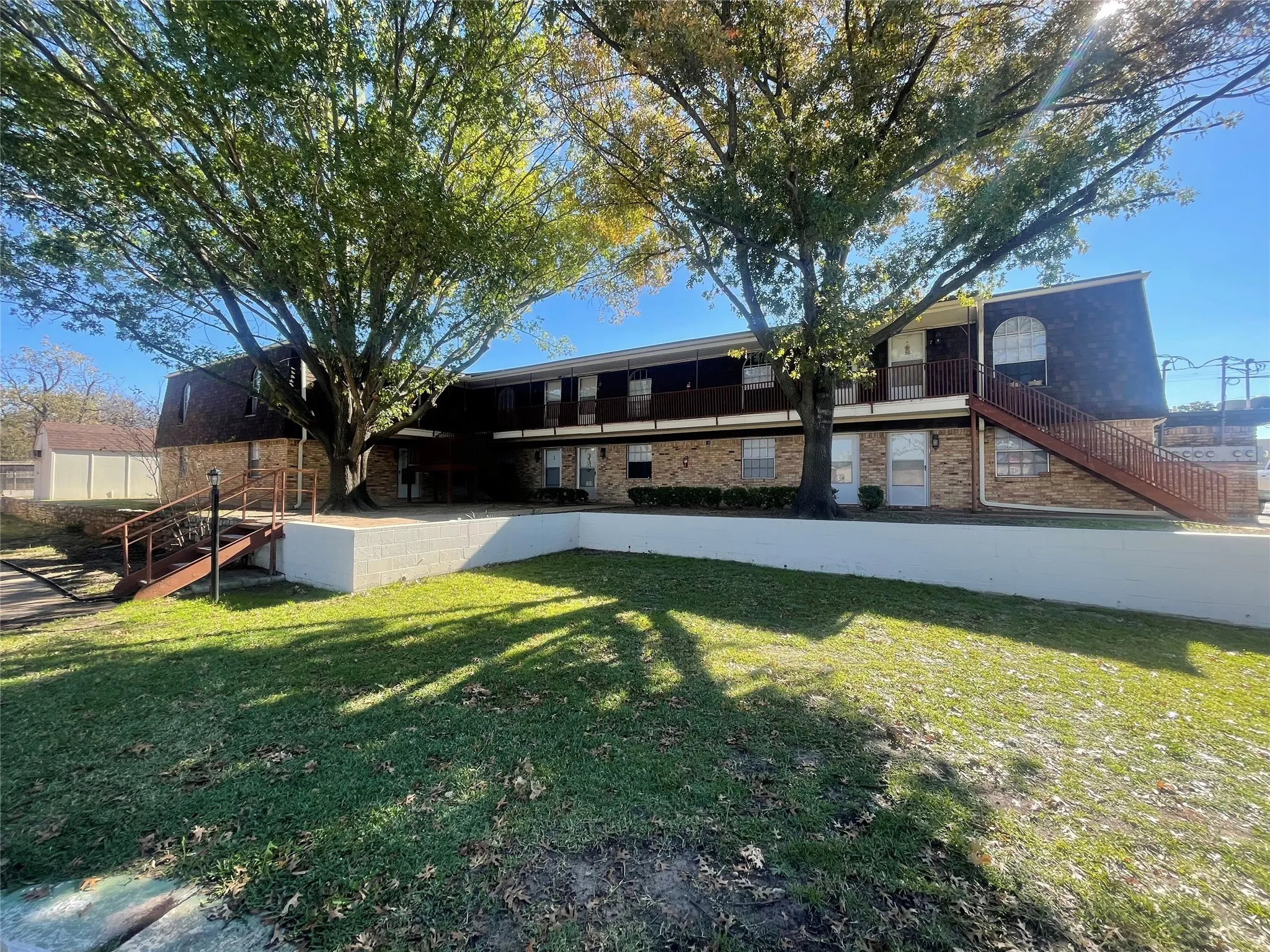 Back of house with a yard, stairway, brick siding, and a patio