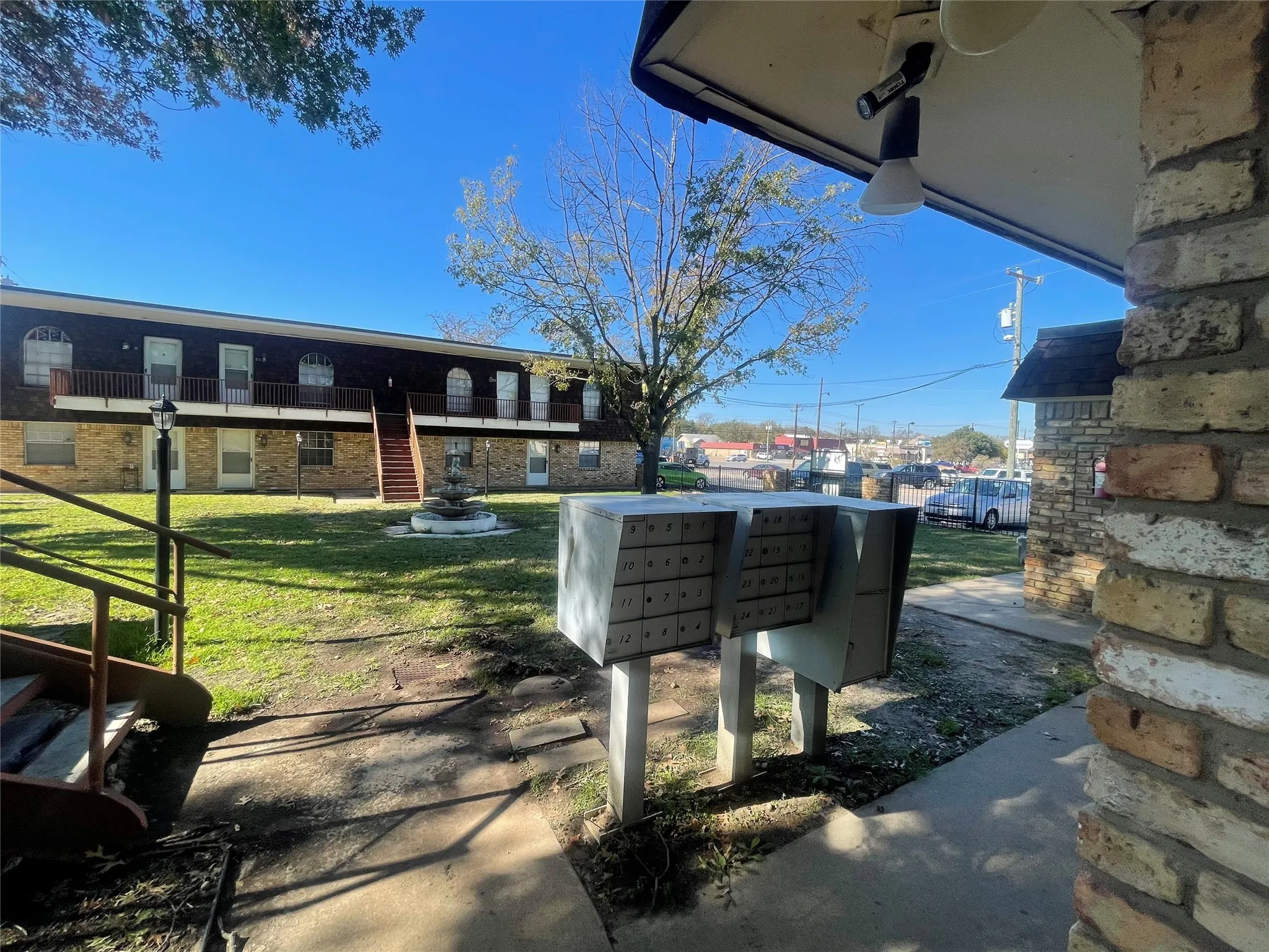View of property's community featuring a patio, stairs, mail area, a yard, and a balcony
