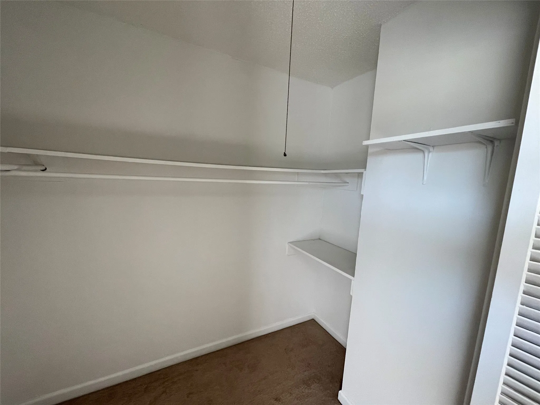 Walk in closet featuring dark carpet
