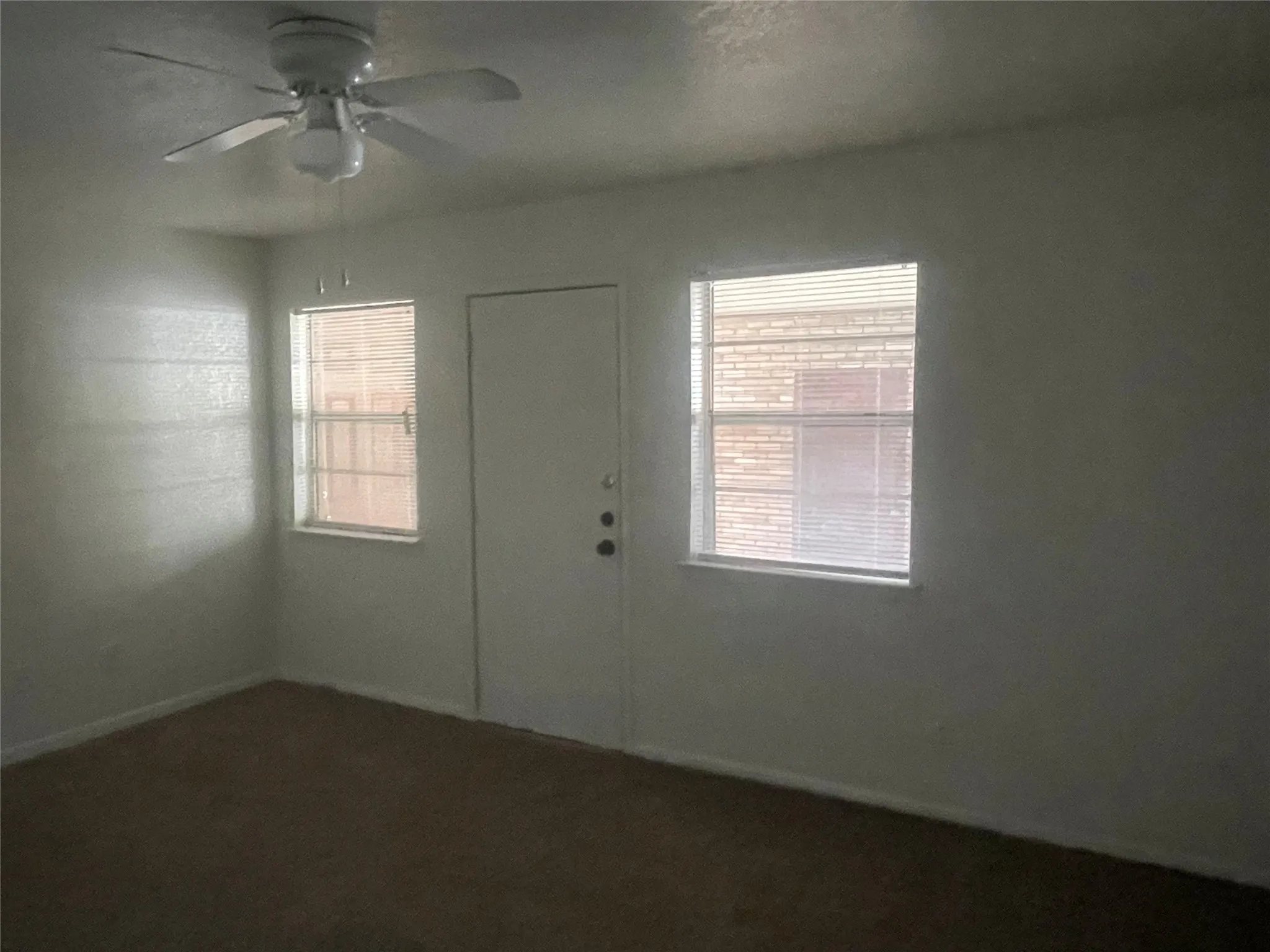 Empty room with healthy amount of natural light and a ceiling fan