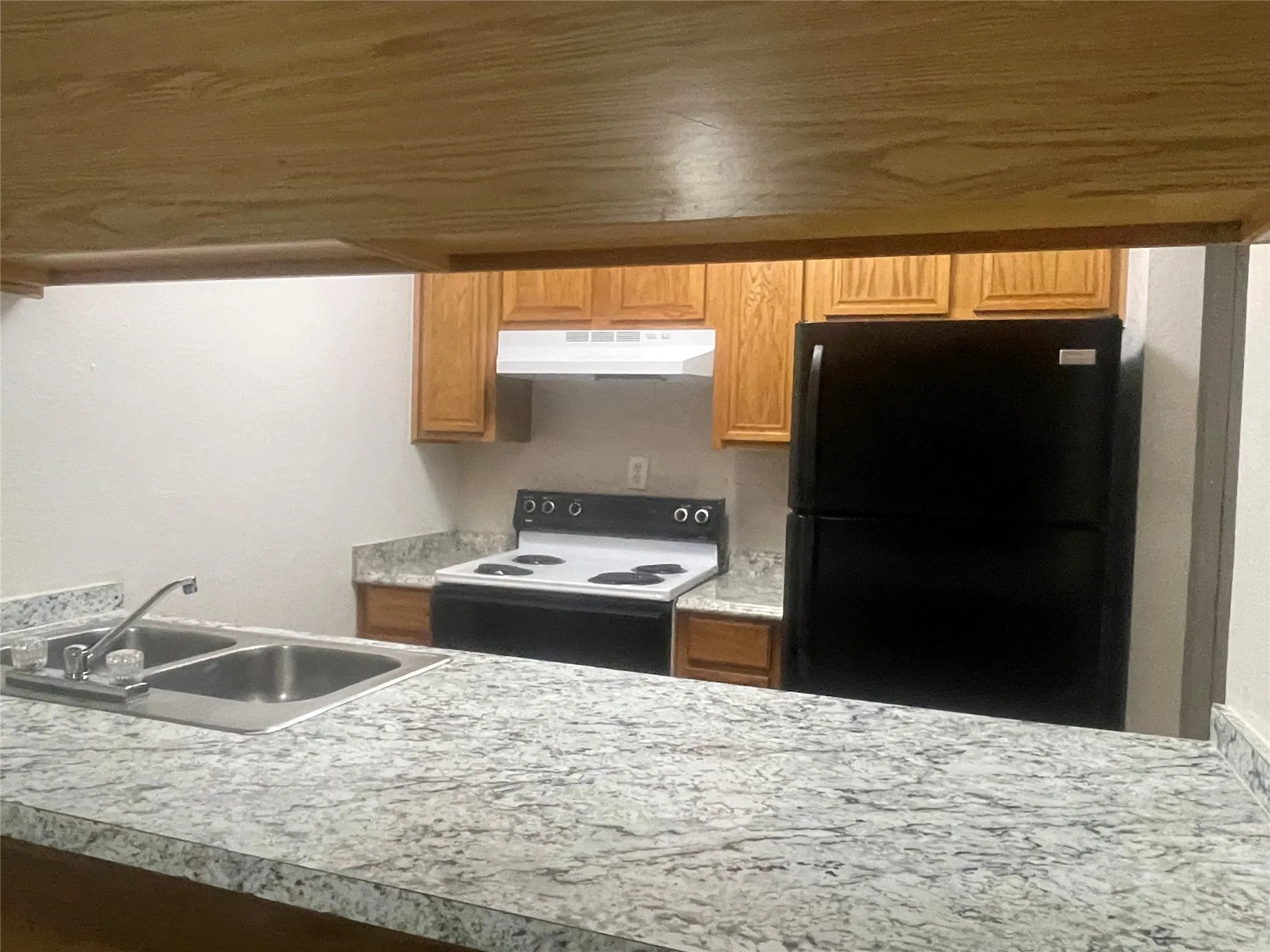 Kitchen featuring range with electric cooktop, freestanding refrigerator, light countertops, a peninsula, and wooden ceiling
