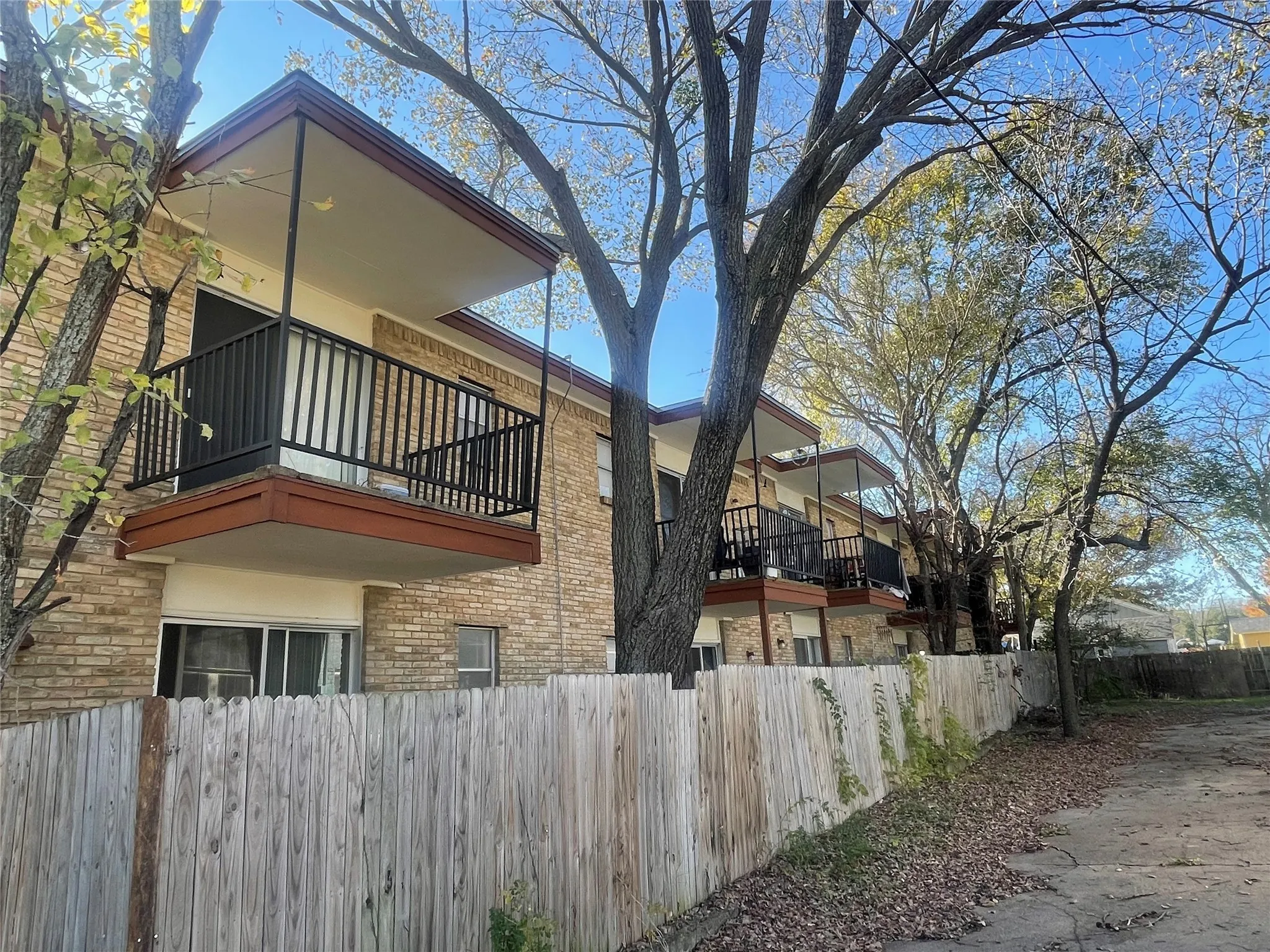 View of side of home with a balcony and brick siding