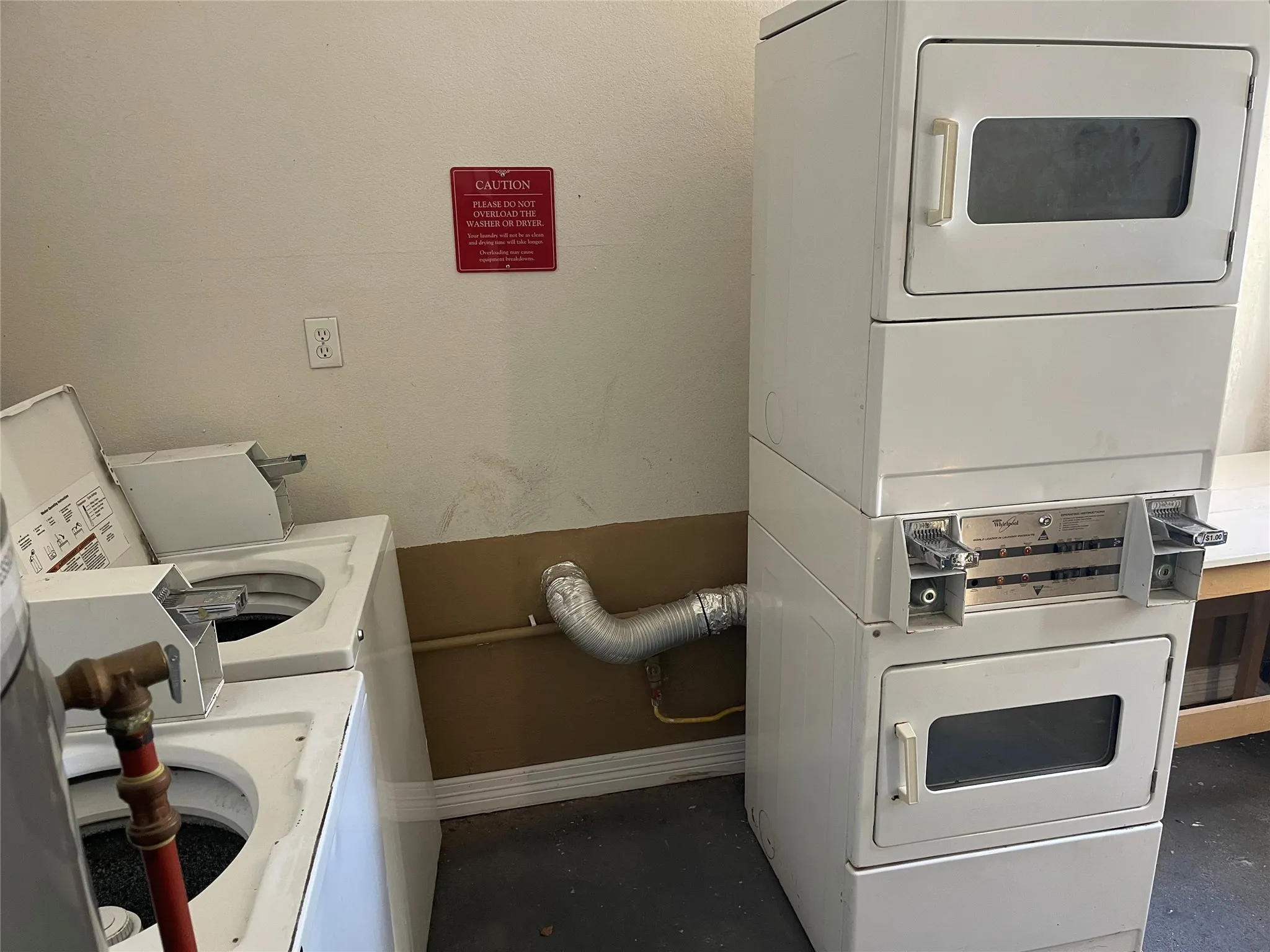 Shared laundry with baseboards and stacked washer / dryer