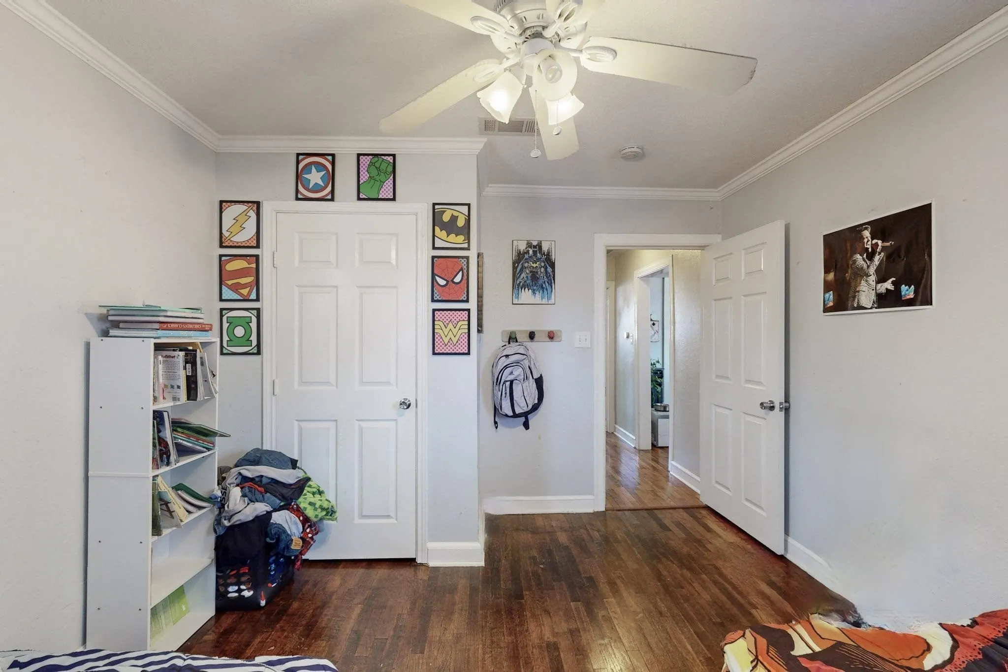 Bedroom with ceiling fan, ornamental molding, and dark wood-type flooring