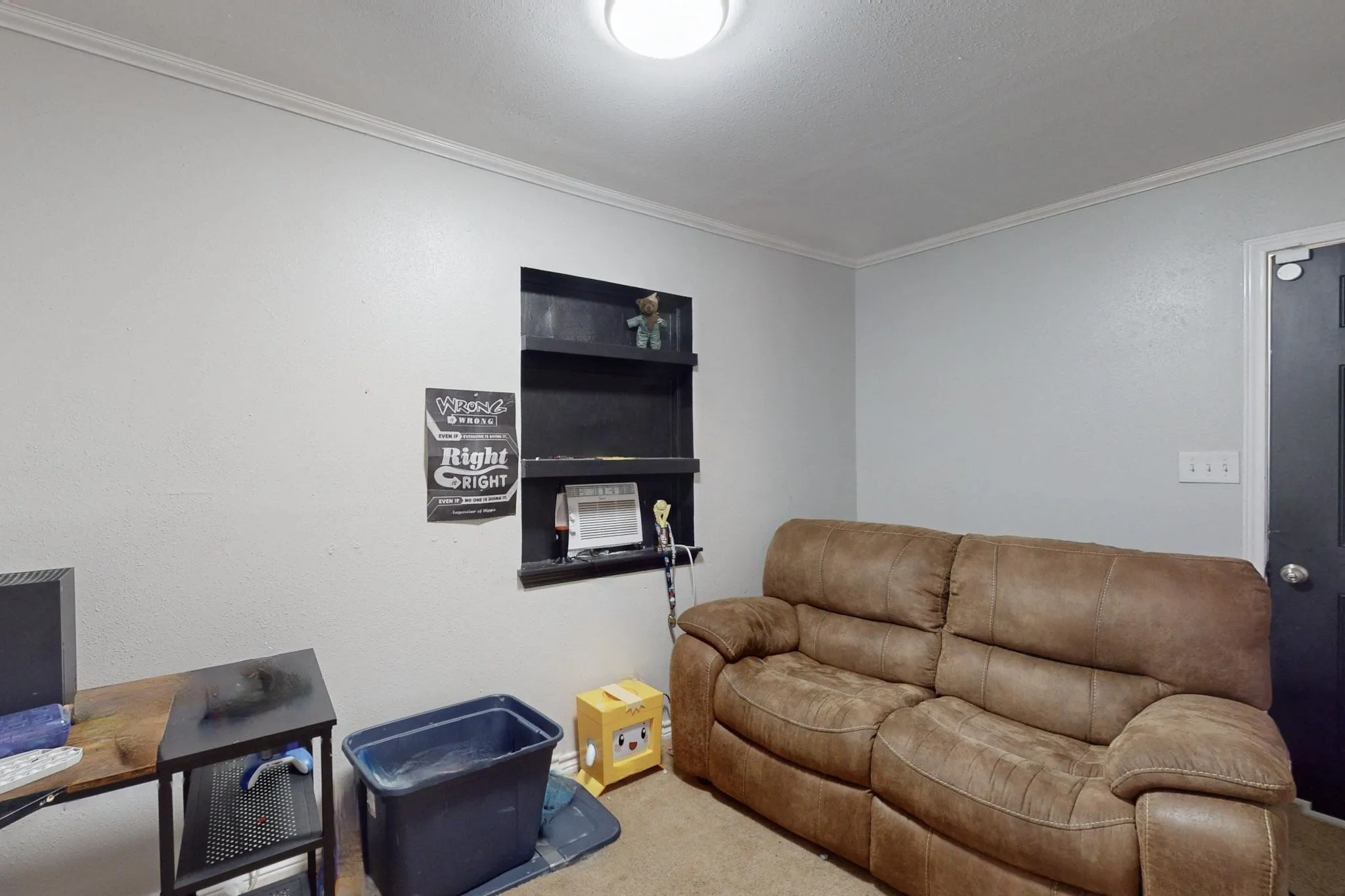 Carpeted living room with ornamental molding and an office area