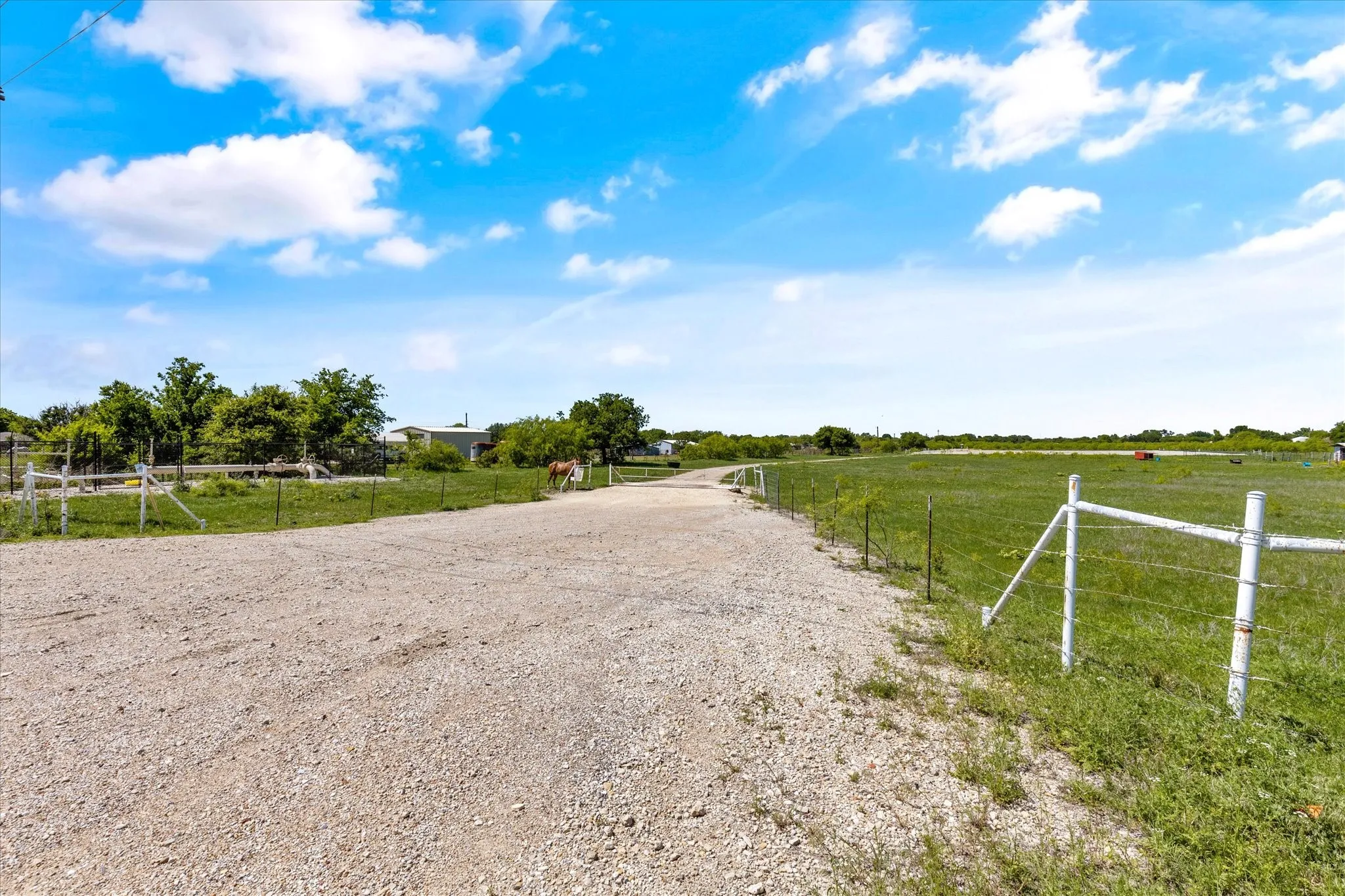 View of dirt / gravel driveway featuring a view of countryside