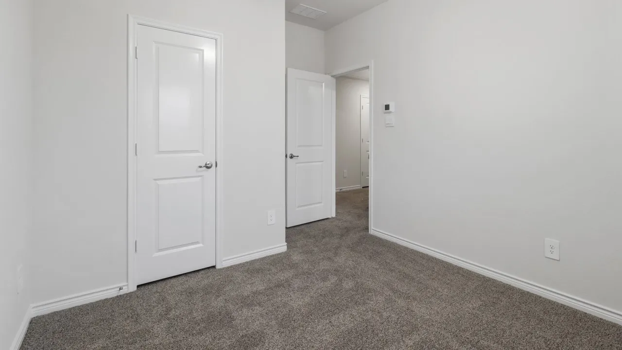 Neutral tone interior with plush gray carpeting, white baseboards, and white walls