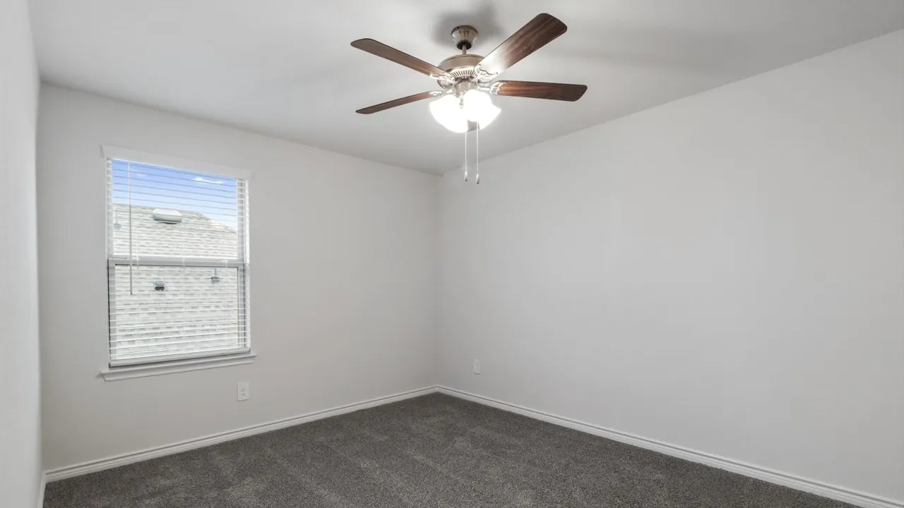 Room featuring light gray walls, gray carpet, and a window with blinds