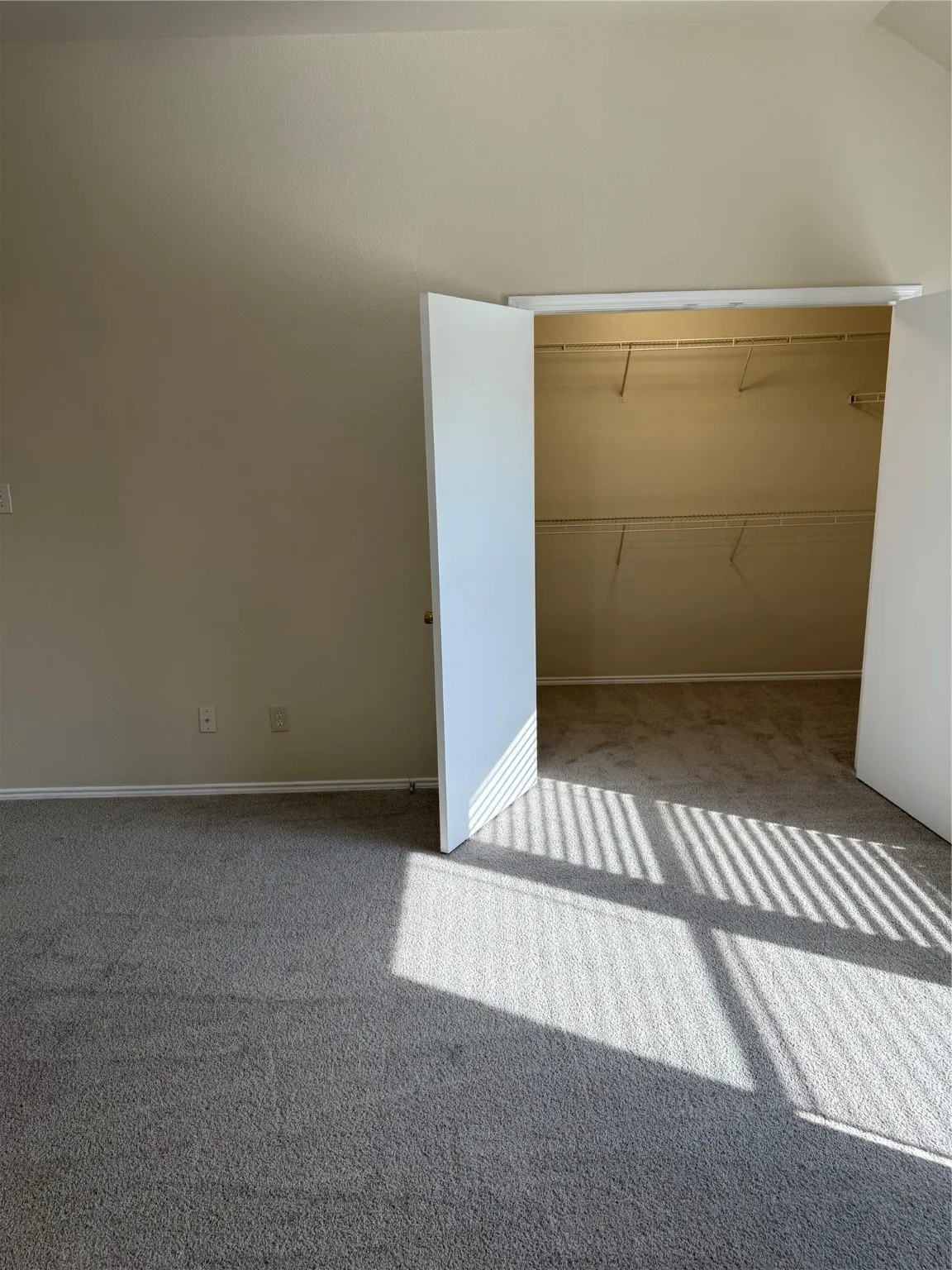 Unfurnished bedroom featuring a closet, carpet floors, and lofted ceiling