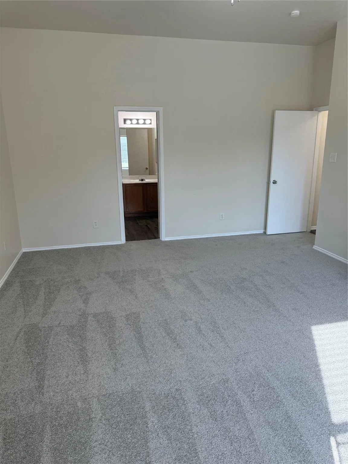 Unfurnished room featuring light colored carpet and baseboards
