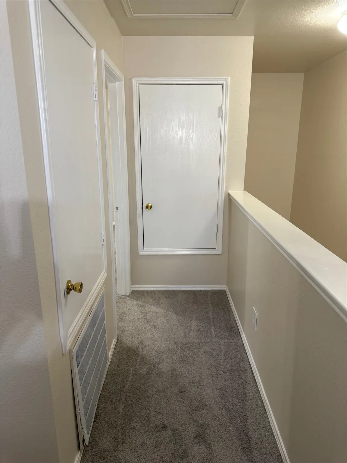 Corridor featuring dark colored carpet