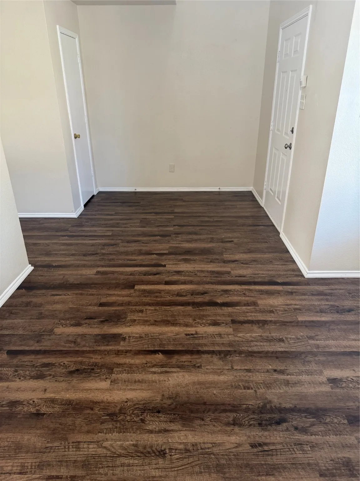 Spare room featuring dark wood finished floors