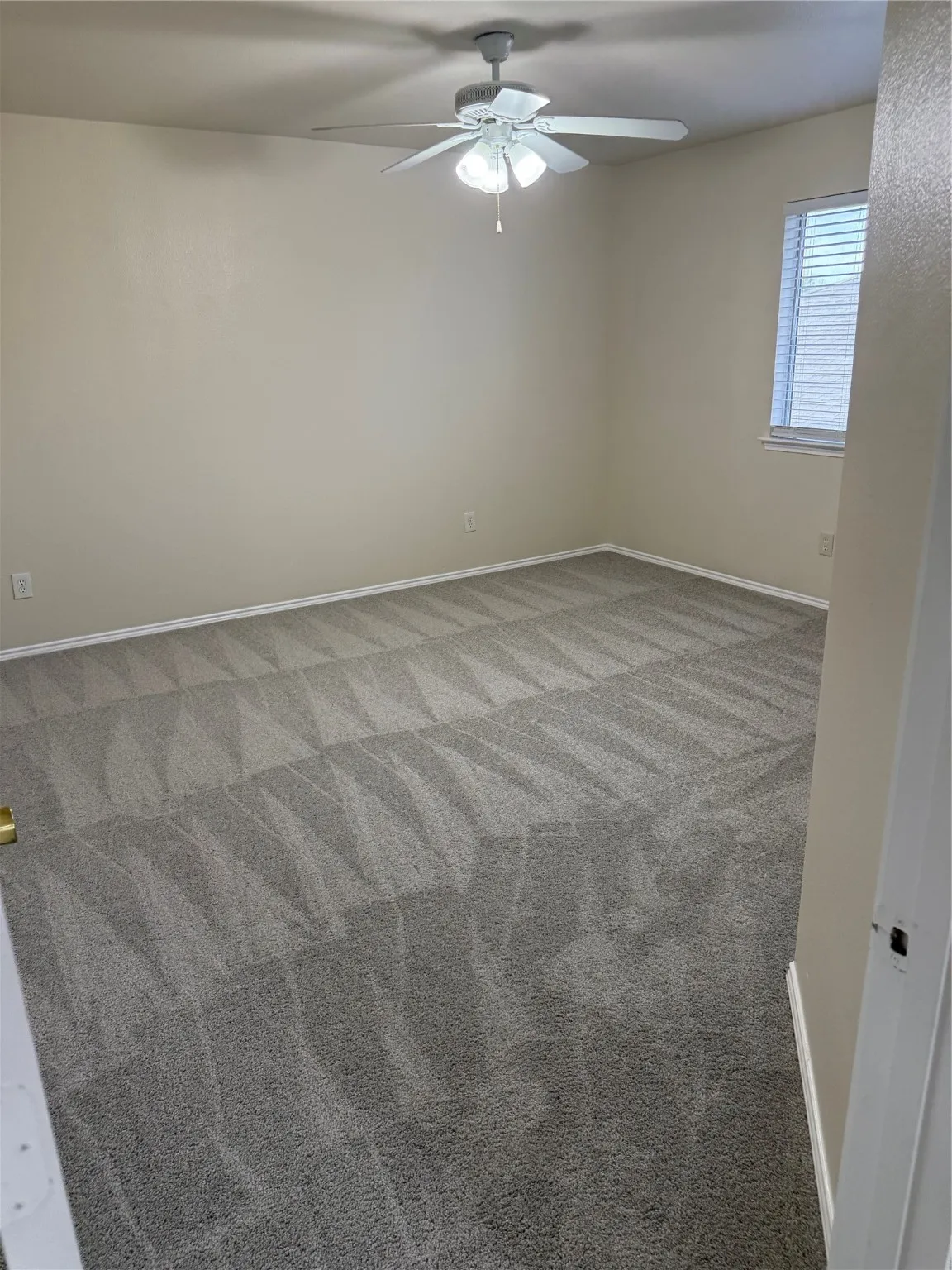 Unfurnished room with carpet floors and a ceiling fan