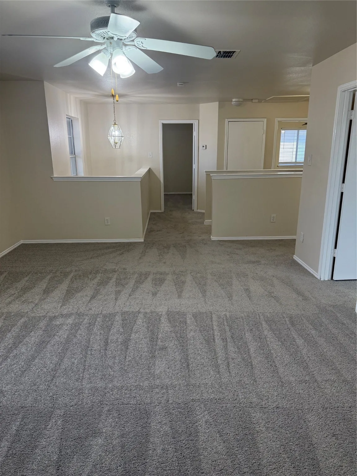 Spare room with light carpet and ceiling fan