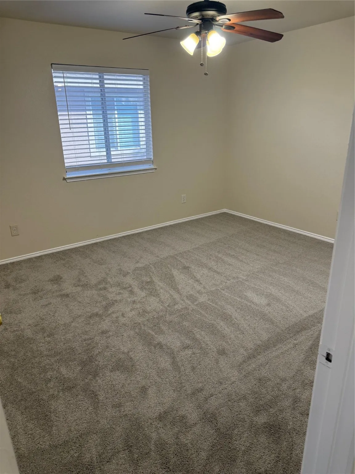 Unfurnished room with ceiling fan and light carpet