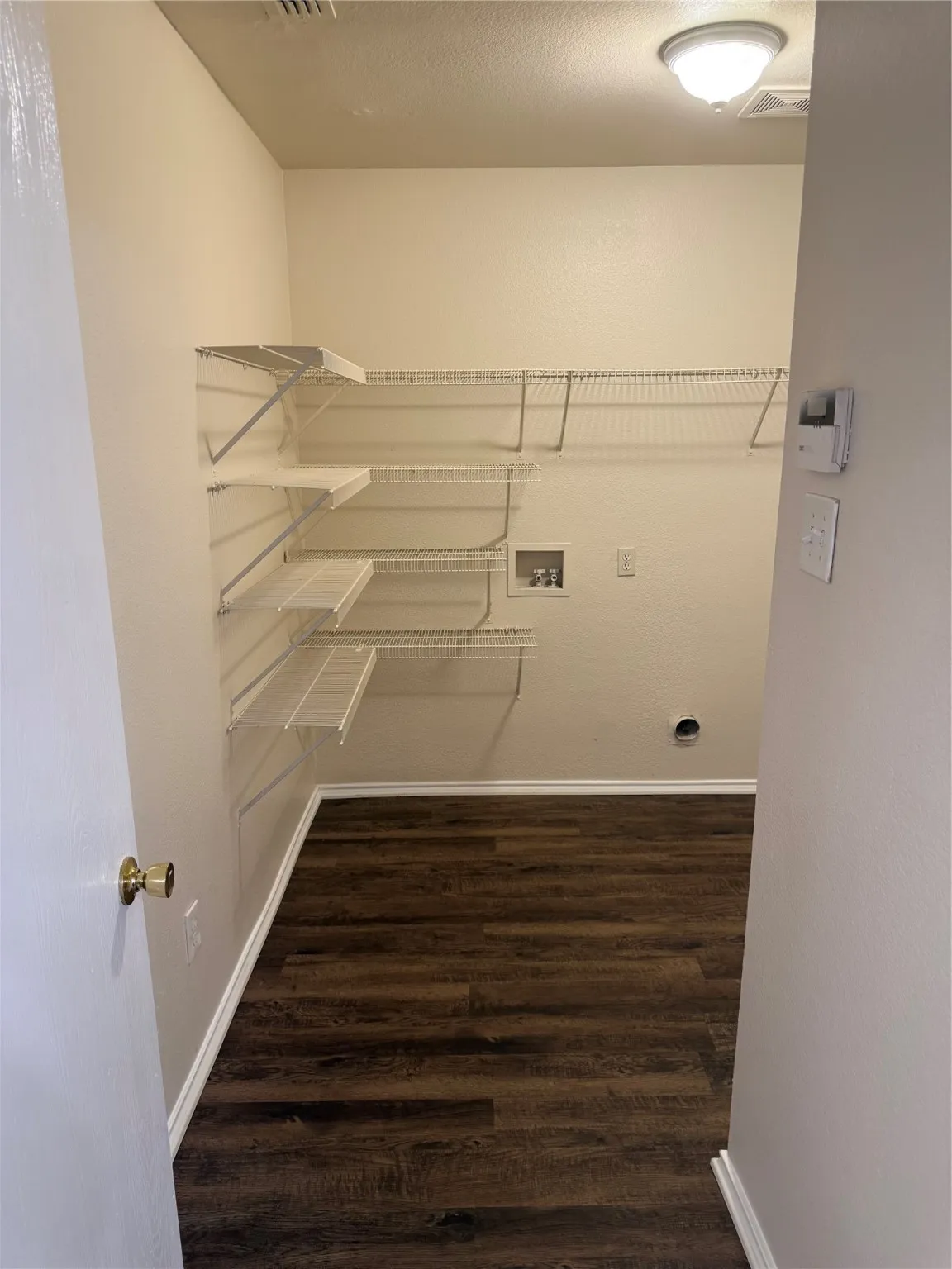 Laundry area with washer hookup, dark wood-style floors, and a textured ceiling