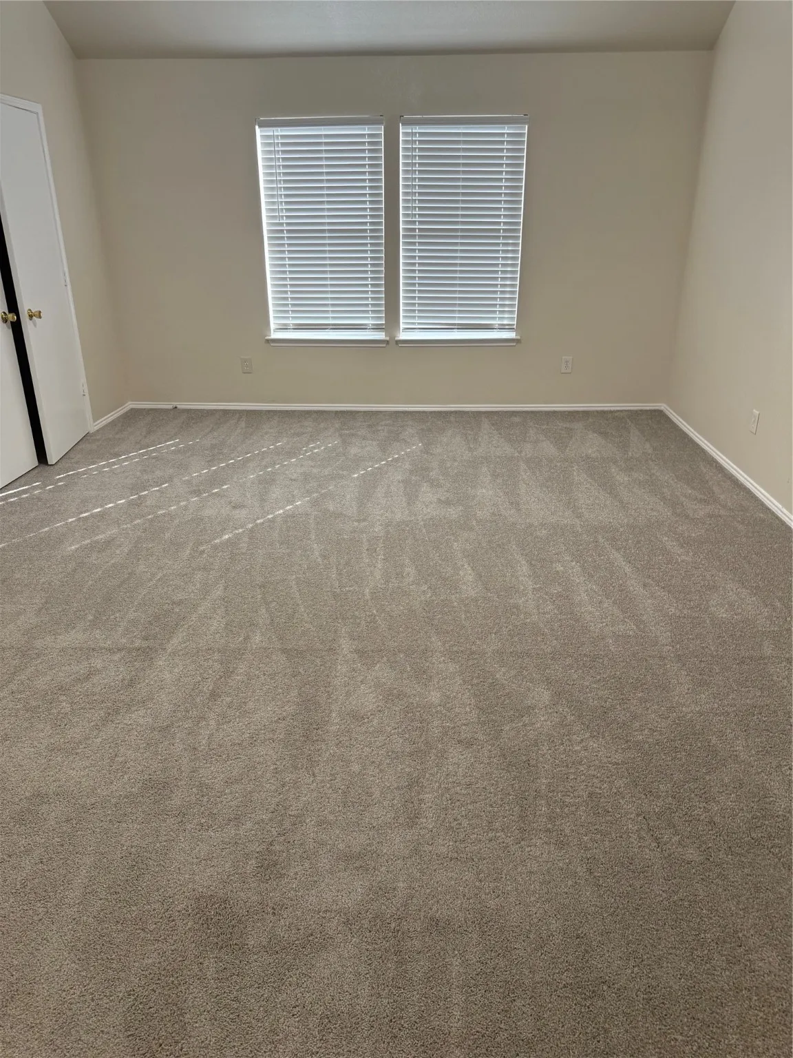 Empty room with light carpet and baseboards
