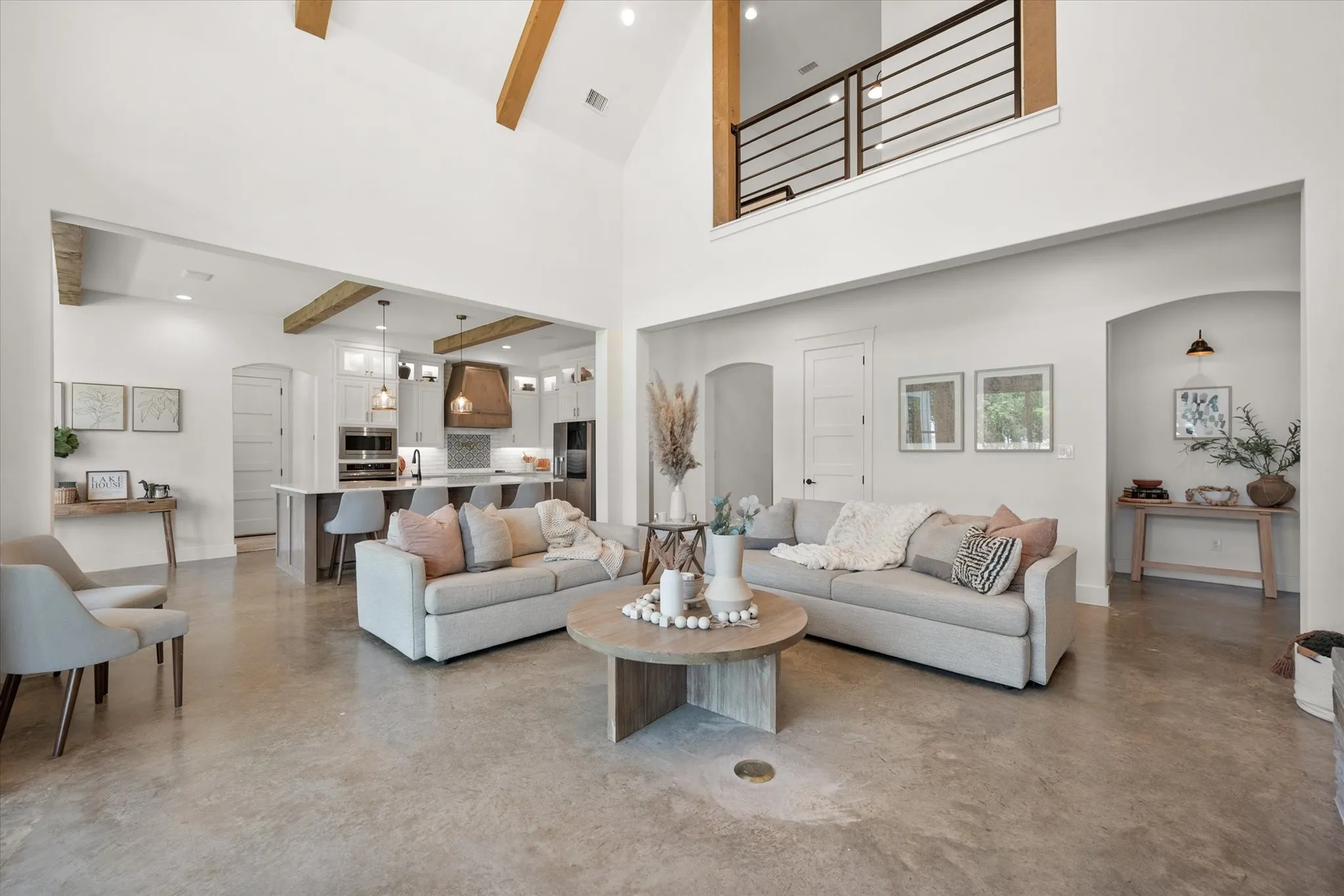 Living room with concrete flooring, beamed ceiling, high vaulted ceiling, and recessed lighting