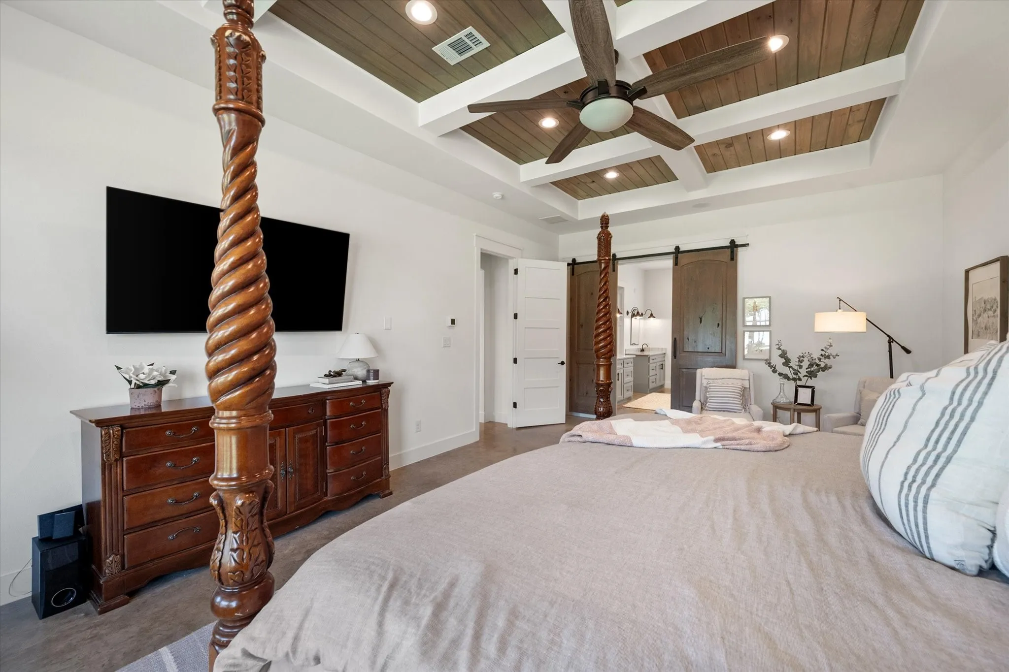 Bedroom featuring a barn door, a wooden ceiling with exposed beams, a ceiling fan, ensuite bathroom, and coffered ceiling