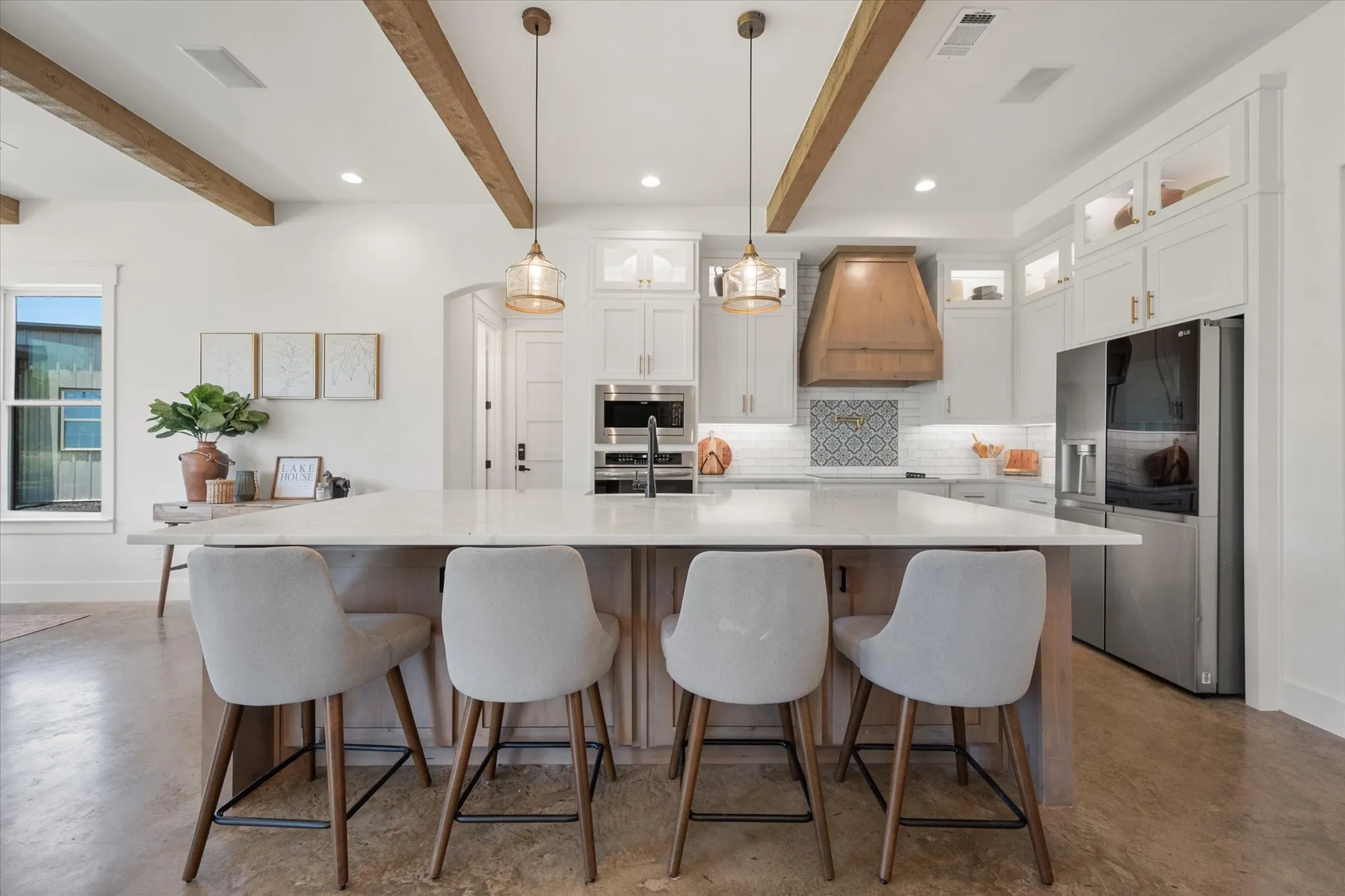 Kitchen with finished concrete flooring, appliances with stainless steel finishes, white cabinets, decorative backsplash, and recessed lighting