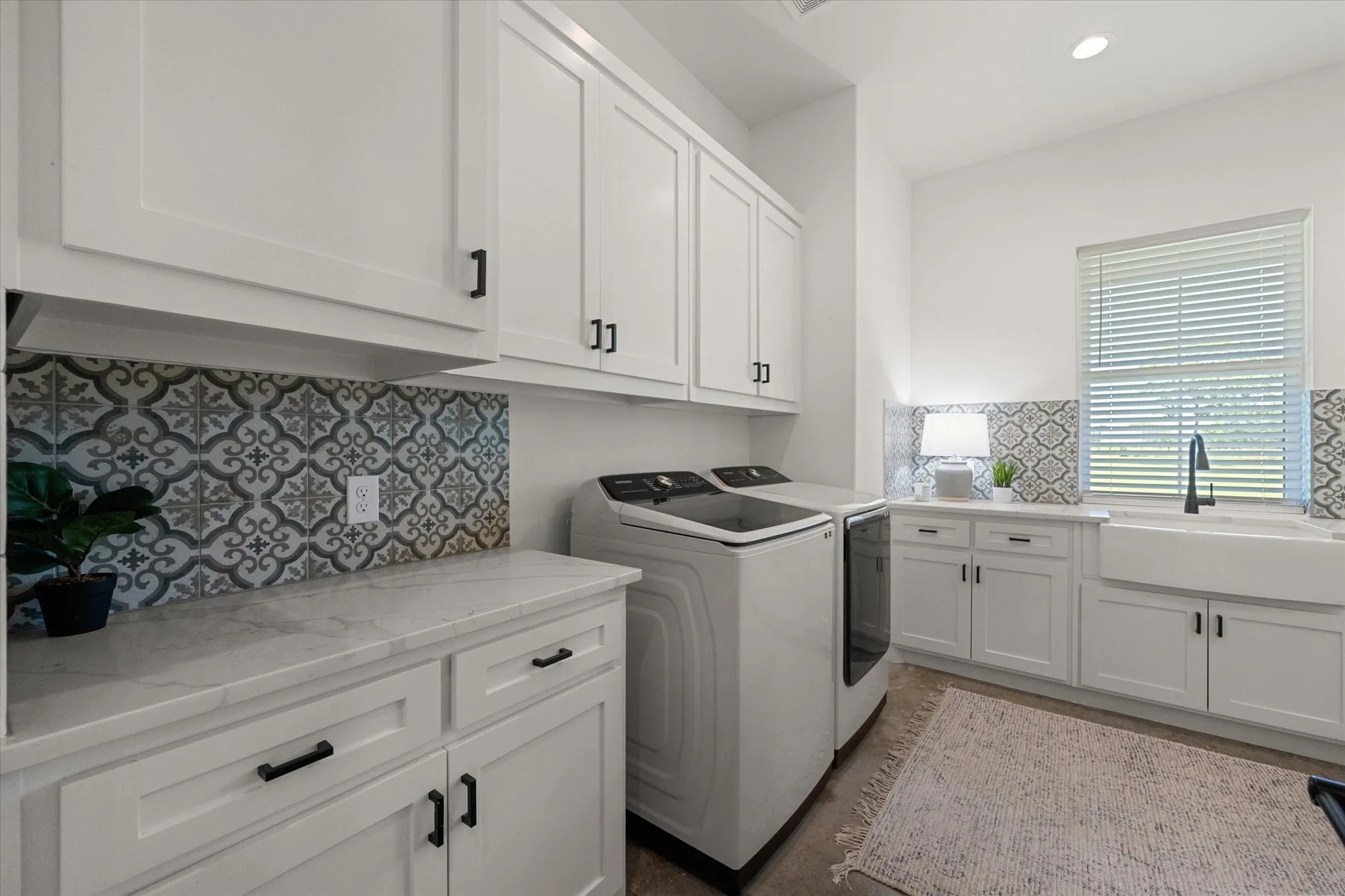 Laundry room with washing machine and dryer, cabinet space, and recessed lighting