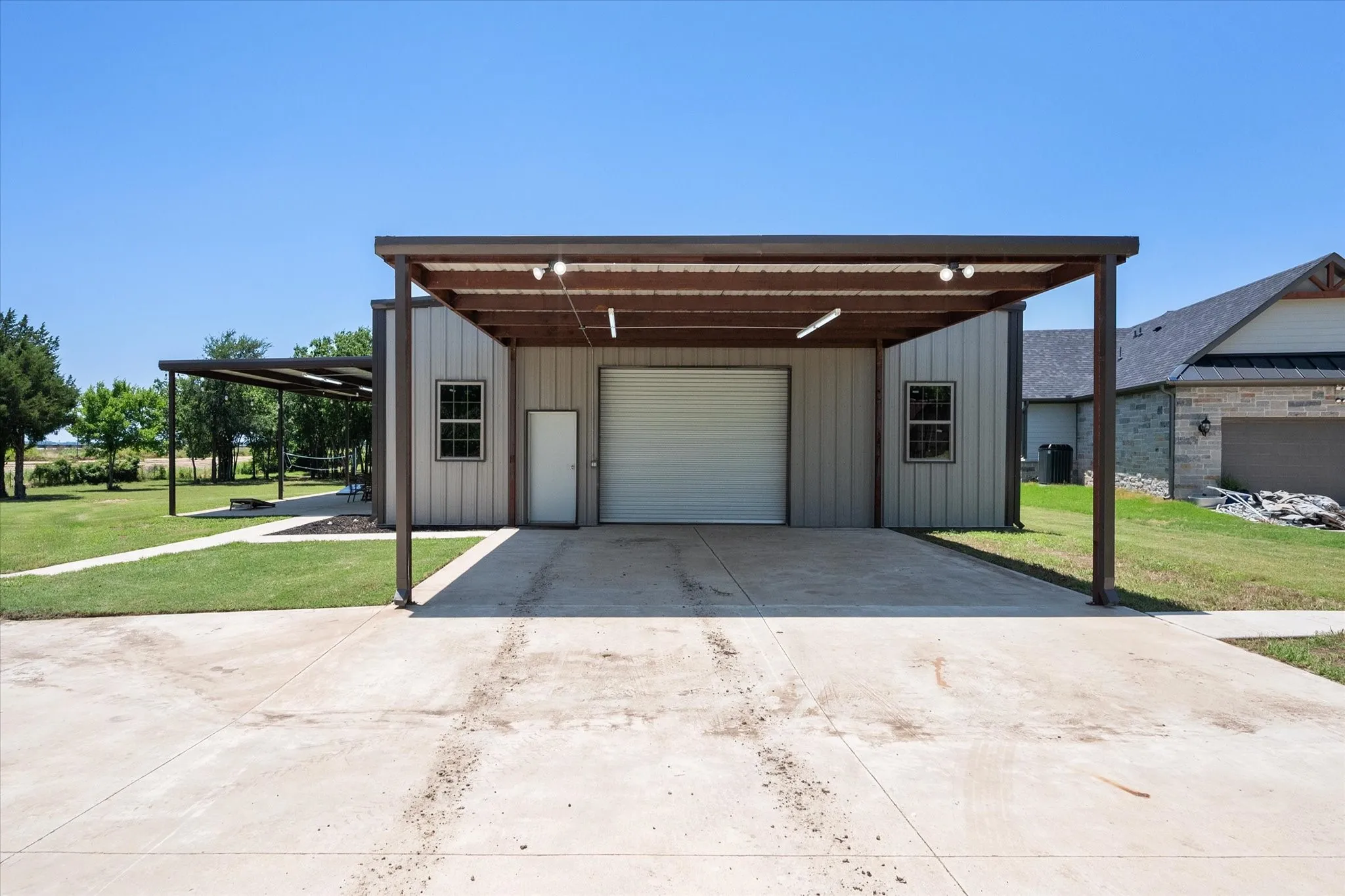 View of front of house featuring board and batten siding, a front lawn, and concrete driveway