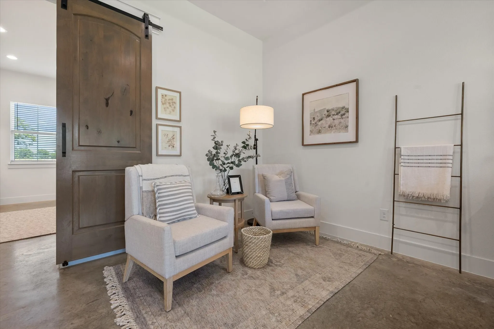 Sitting room featuring a barn door and finished concrete flooring