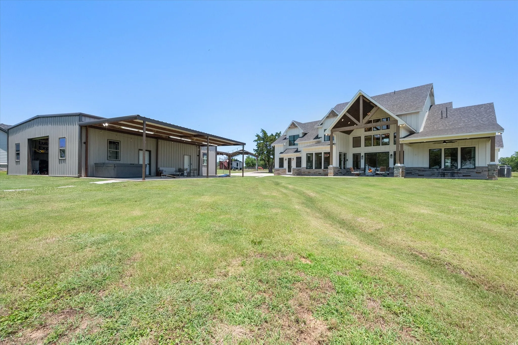 Rear view of house with a lawn, ceiling fan, a patio, and roof with shingles