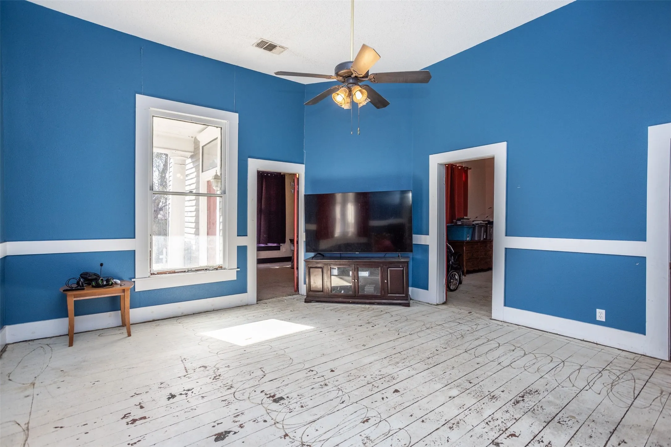 Soaring ceilings in Living room with a ceiling fan and hardwood / wood-style flooring