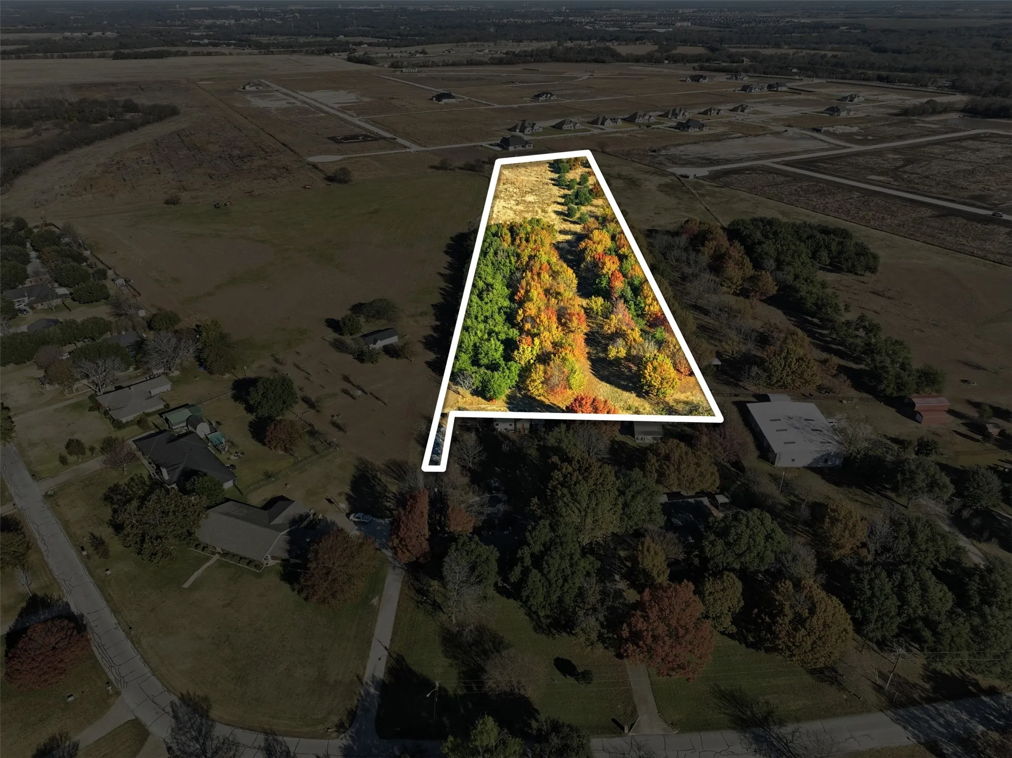 Aerial view of sparsely populated area featuring property parcel outlined