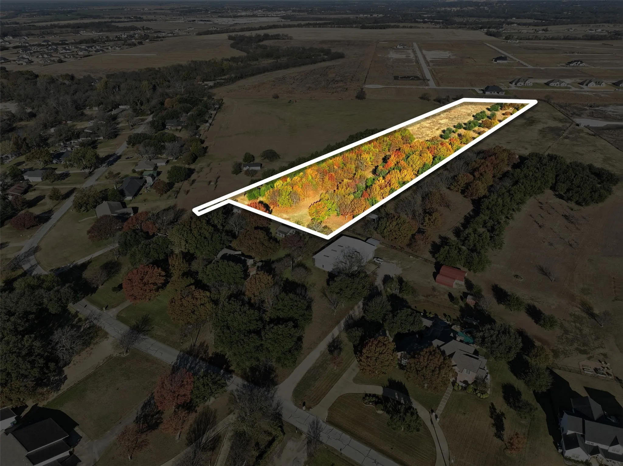 Aerial view of sparsely populated area featuring property parcel outlined