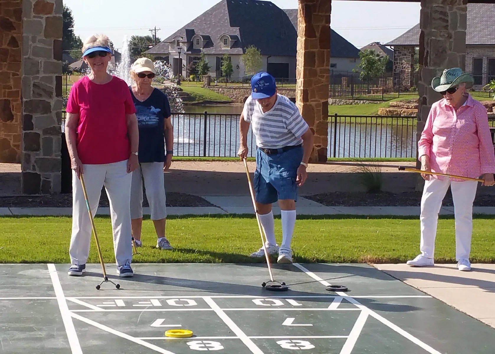 View of property's community featuring a water view and shuffleboard