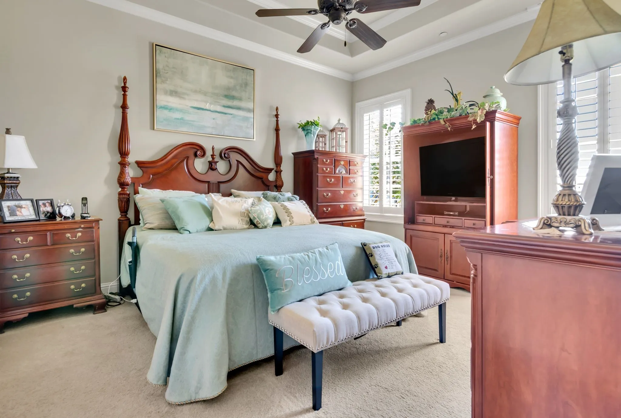 Bedroom with crown molding, light colored carpet, ceiling fan, and a raised ceiling
