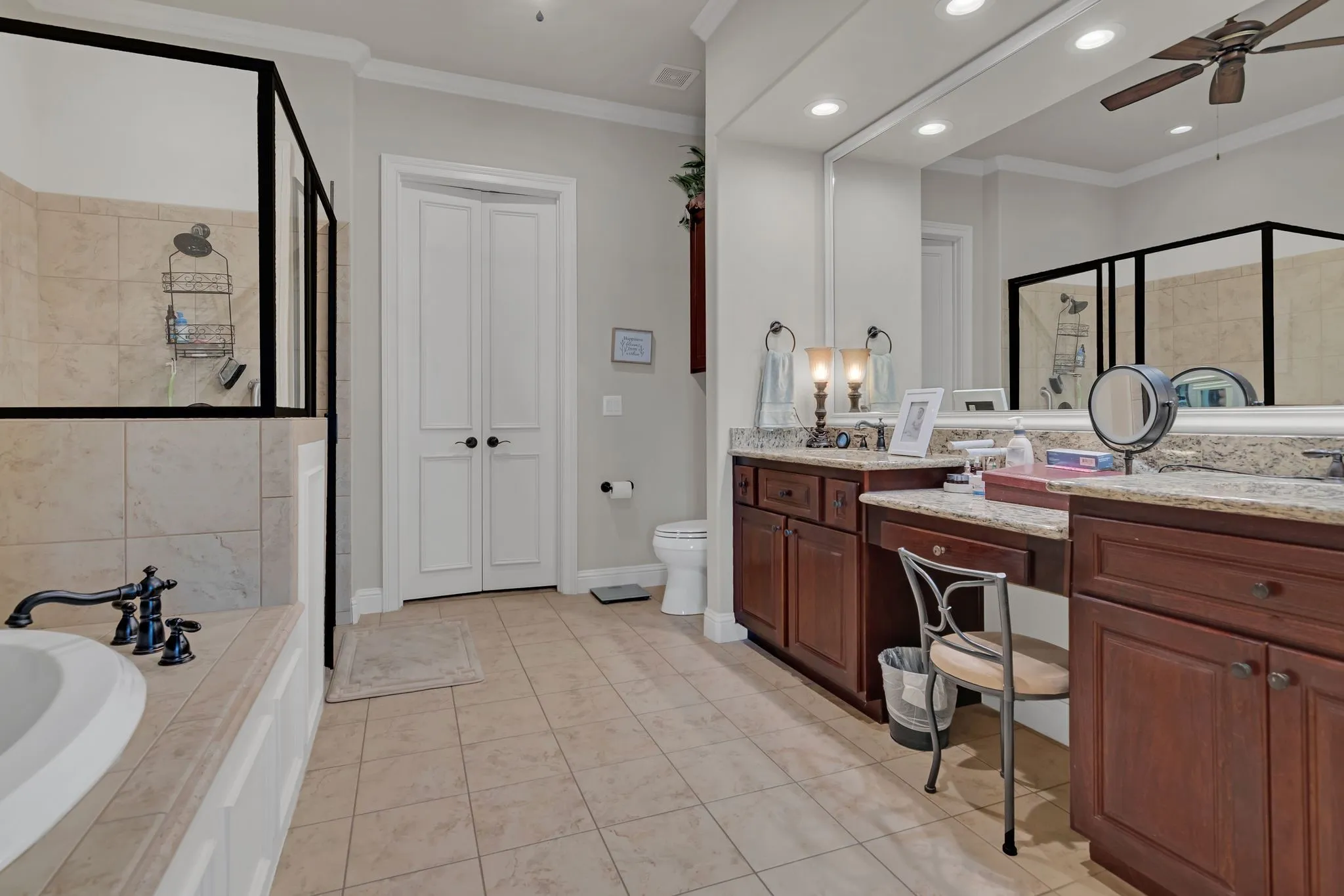 Full bathroom with crown molding, ceiling fan, vanity, a stall shower, and a jetted tub