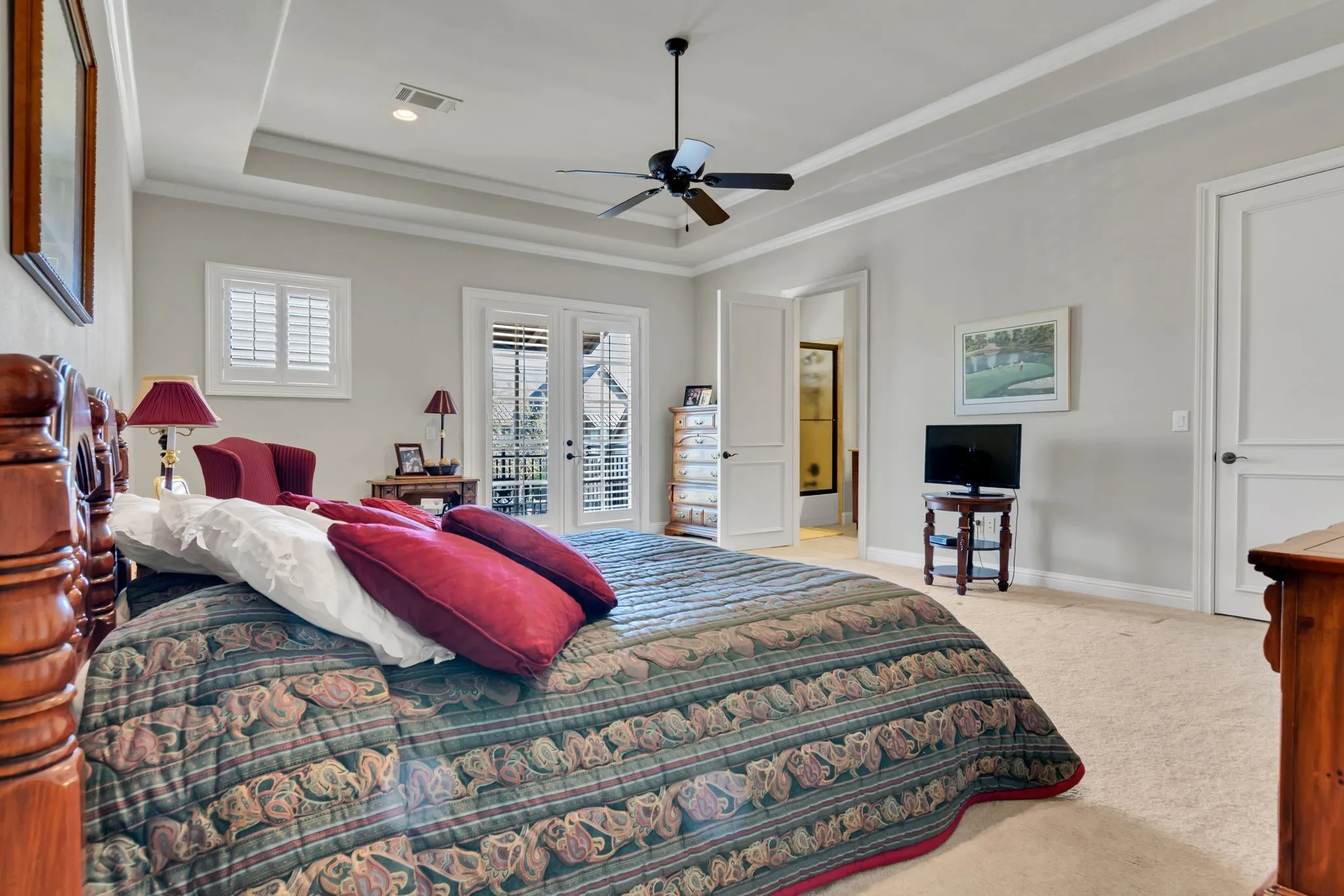 Bonus room with full bath, closet and balcony, featuring ornamental molding, light colored carpet, a ceiling fan, and raised ceiling.  Can be used as game room or 3rd bedroom.