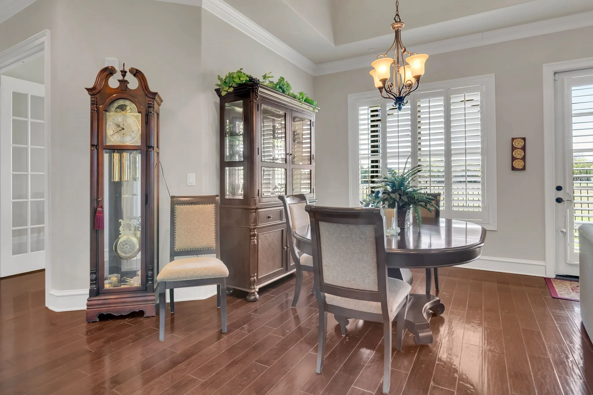 Partial view of Living room, featuring crown molding, dark wood-style flooring, and a chandelier