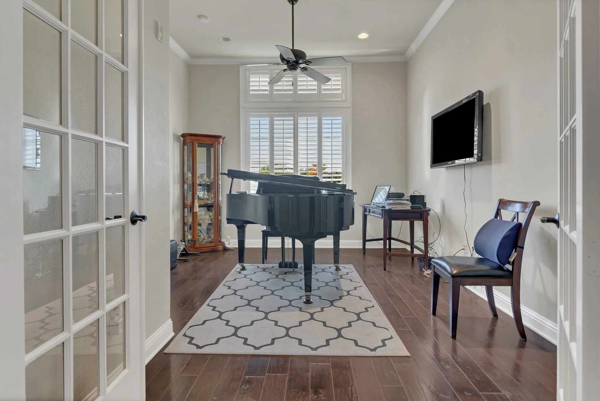 Office with dark wood finished floors, ornamental molding, and a ceiling fan