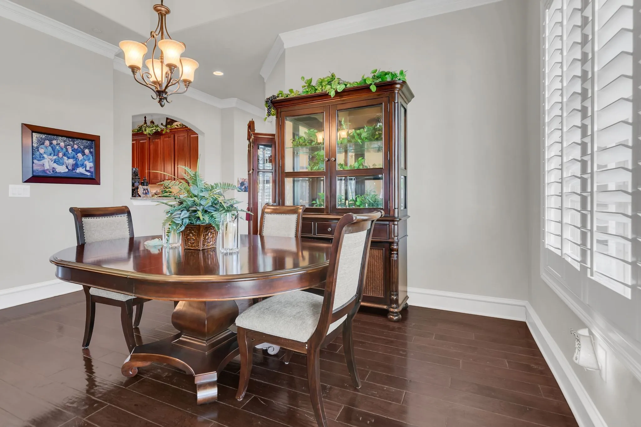 Partial view of living room with wood finish floors, ornamental molding, a chandelier, and recessed lighting