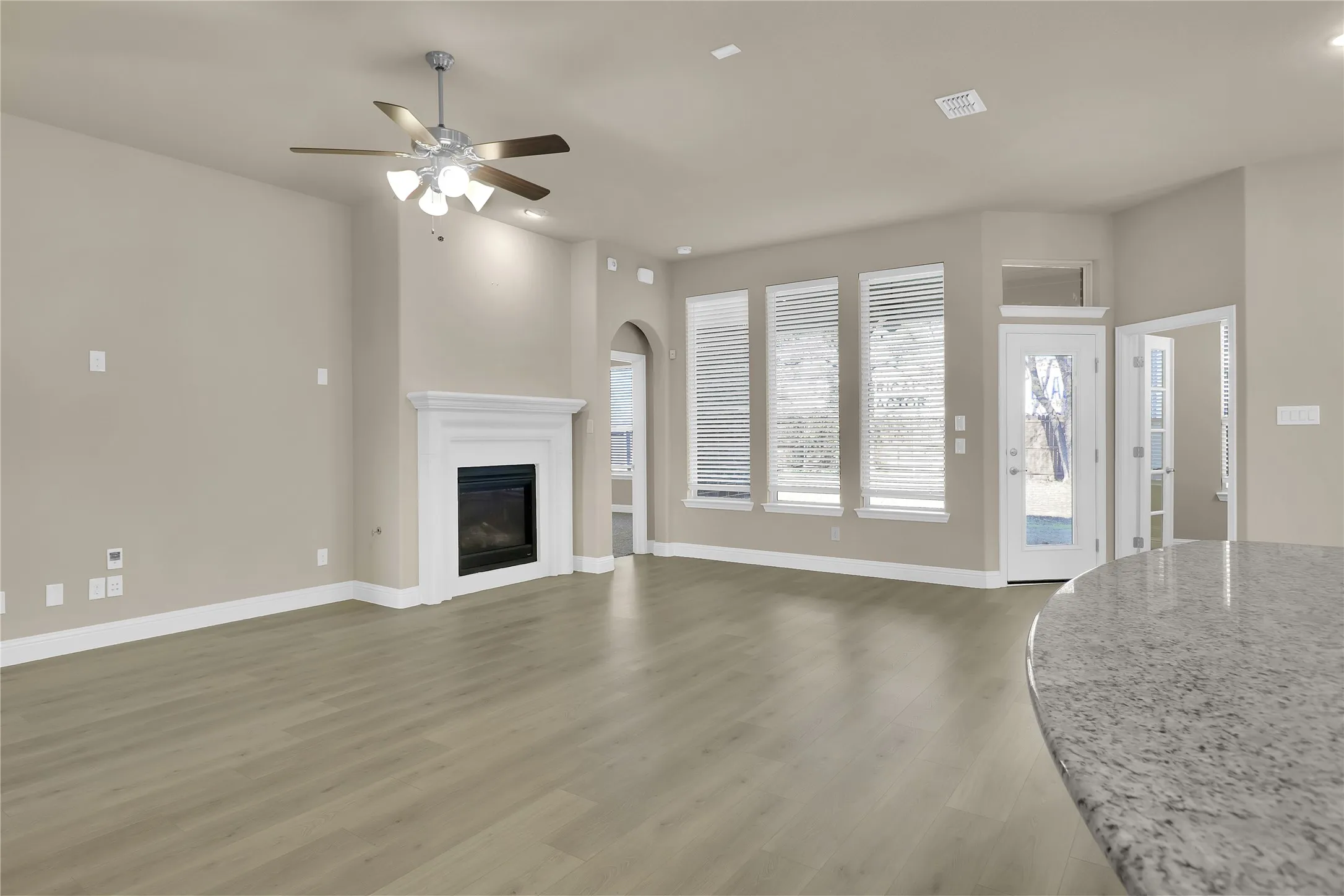 Another view of the spacious living room and windows that overlook the backyard.