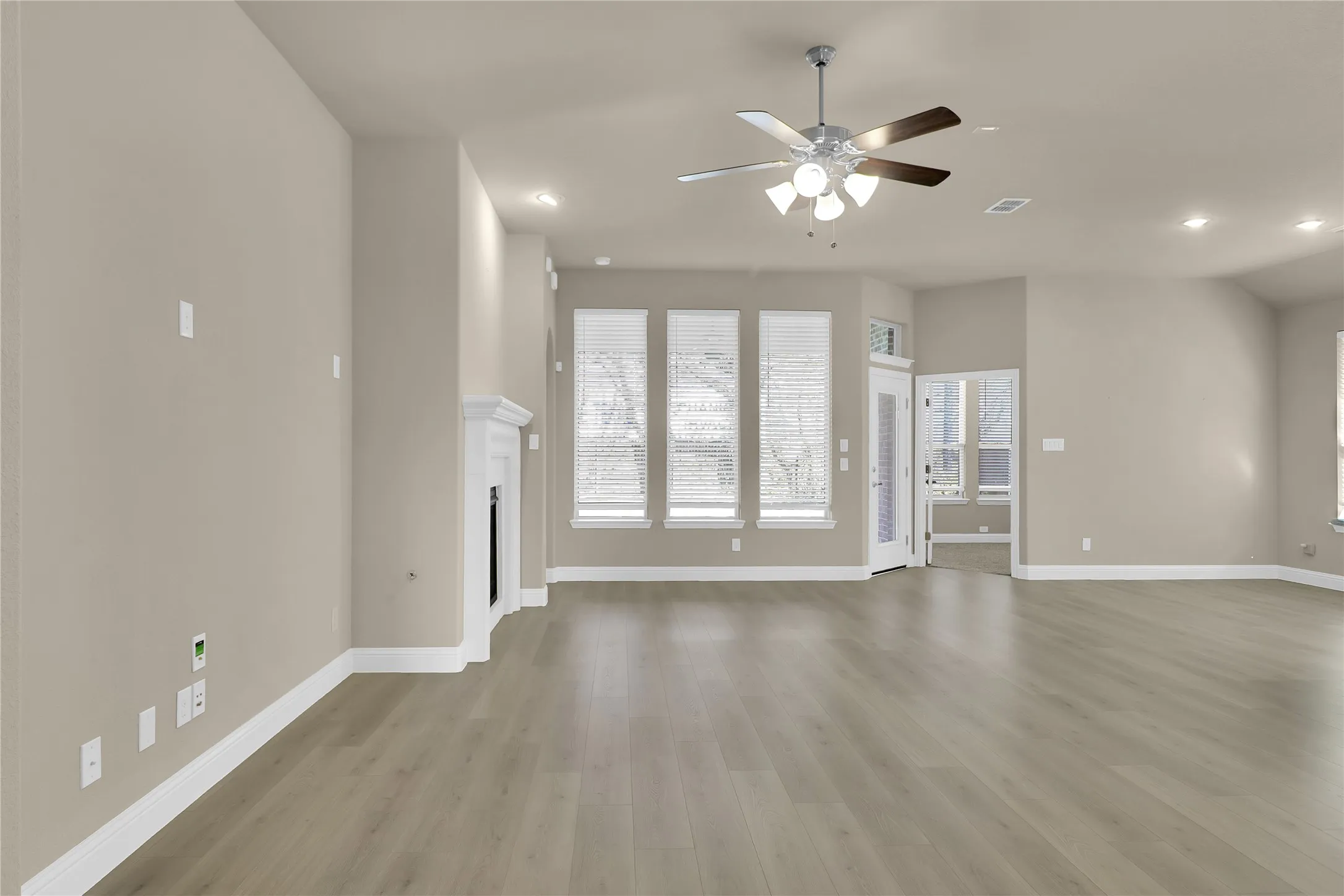 Living room featuring recessed lighting, luxury vinyl plank flooring, a gas fireplace, and a ceiling fan and so much natural light.