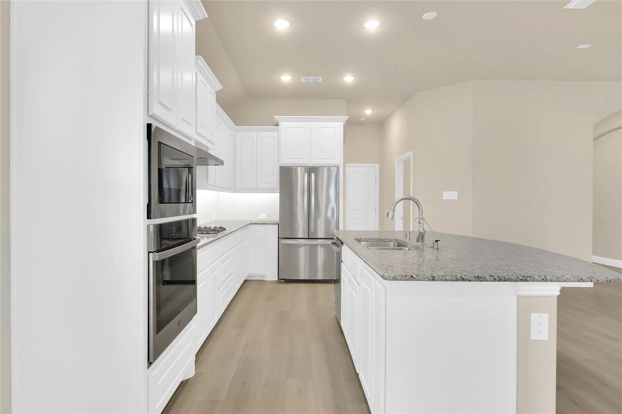 Long view of bright and light kitchen. Gas cooktop!