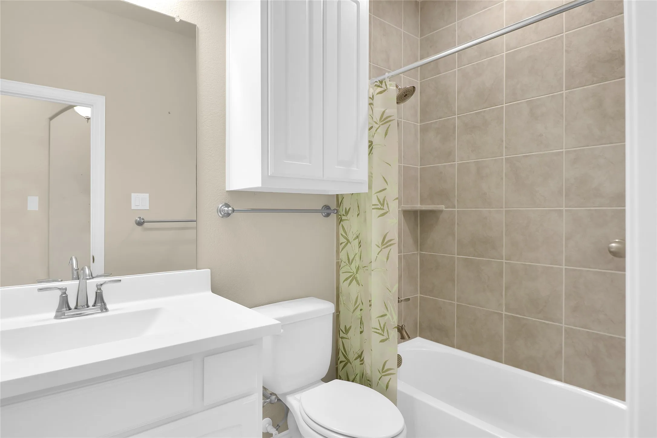 Secondary bathroom featuring shower / tub combo with curtain and vanity