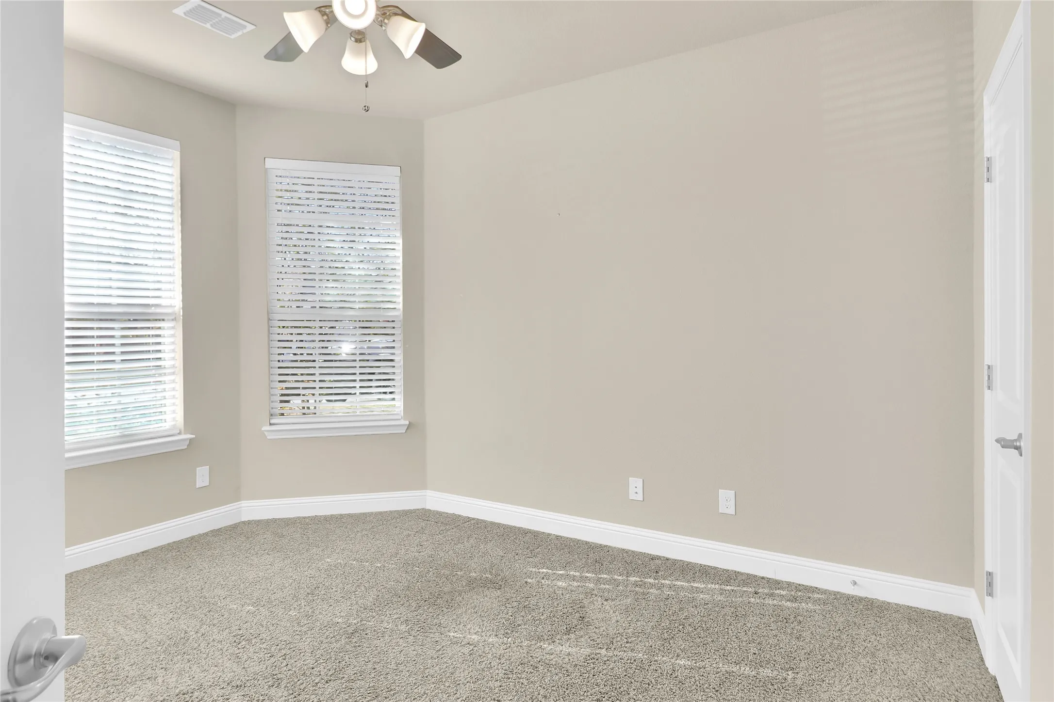 Spacious bedroom with ceiling fan.