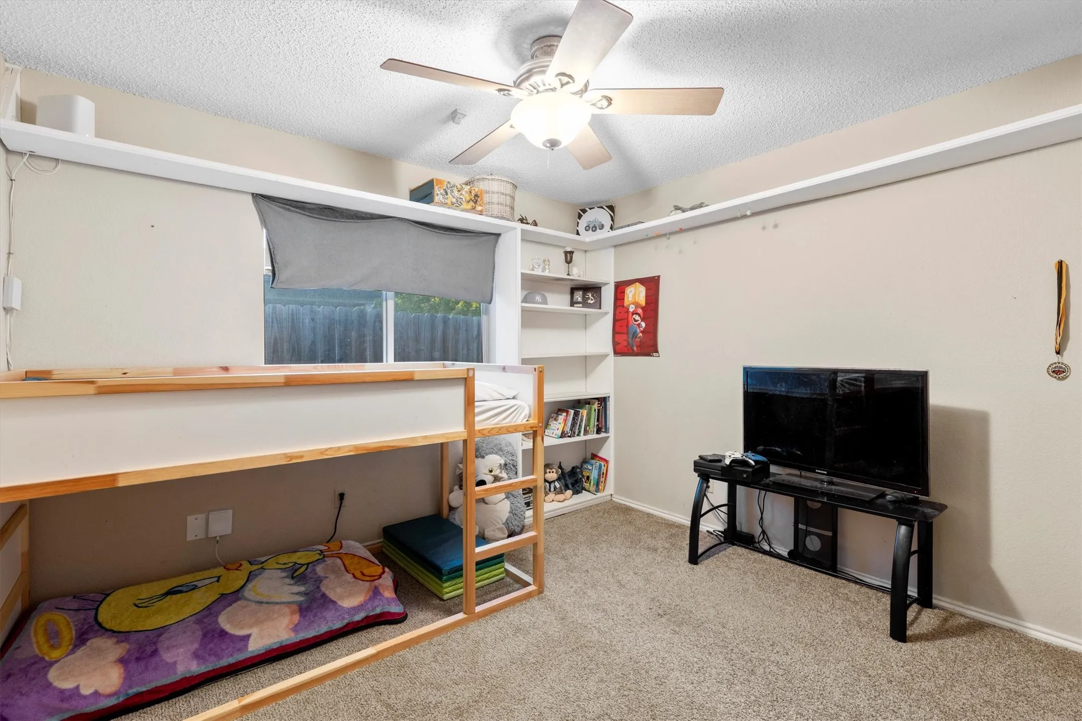 Bedroom with light colored carpet, a textured ceiling, and a ceiling fan